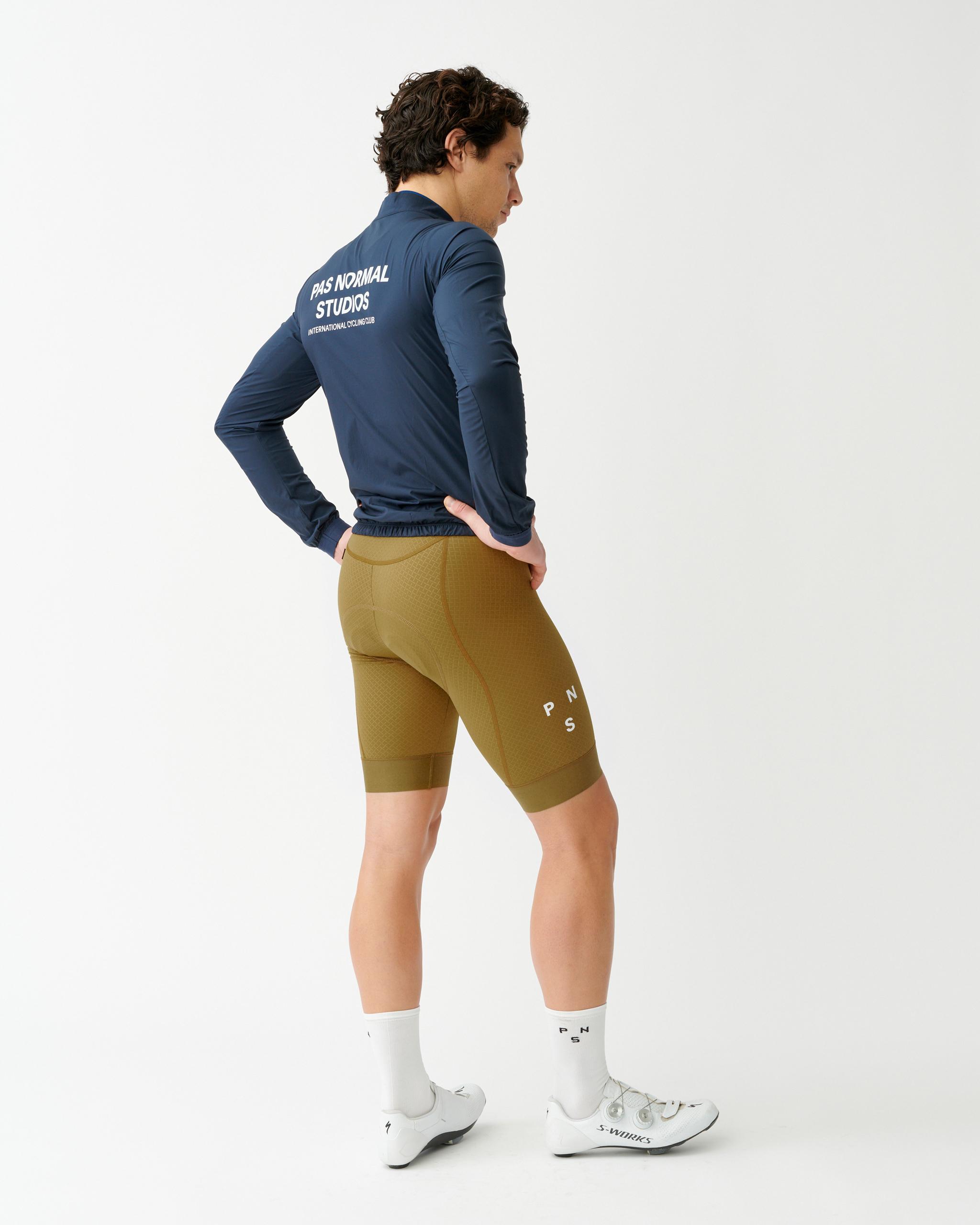 Navy Mechanism Stow Away jacket on model, rear three-quarter view with white back logo