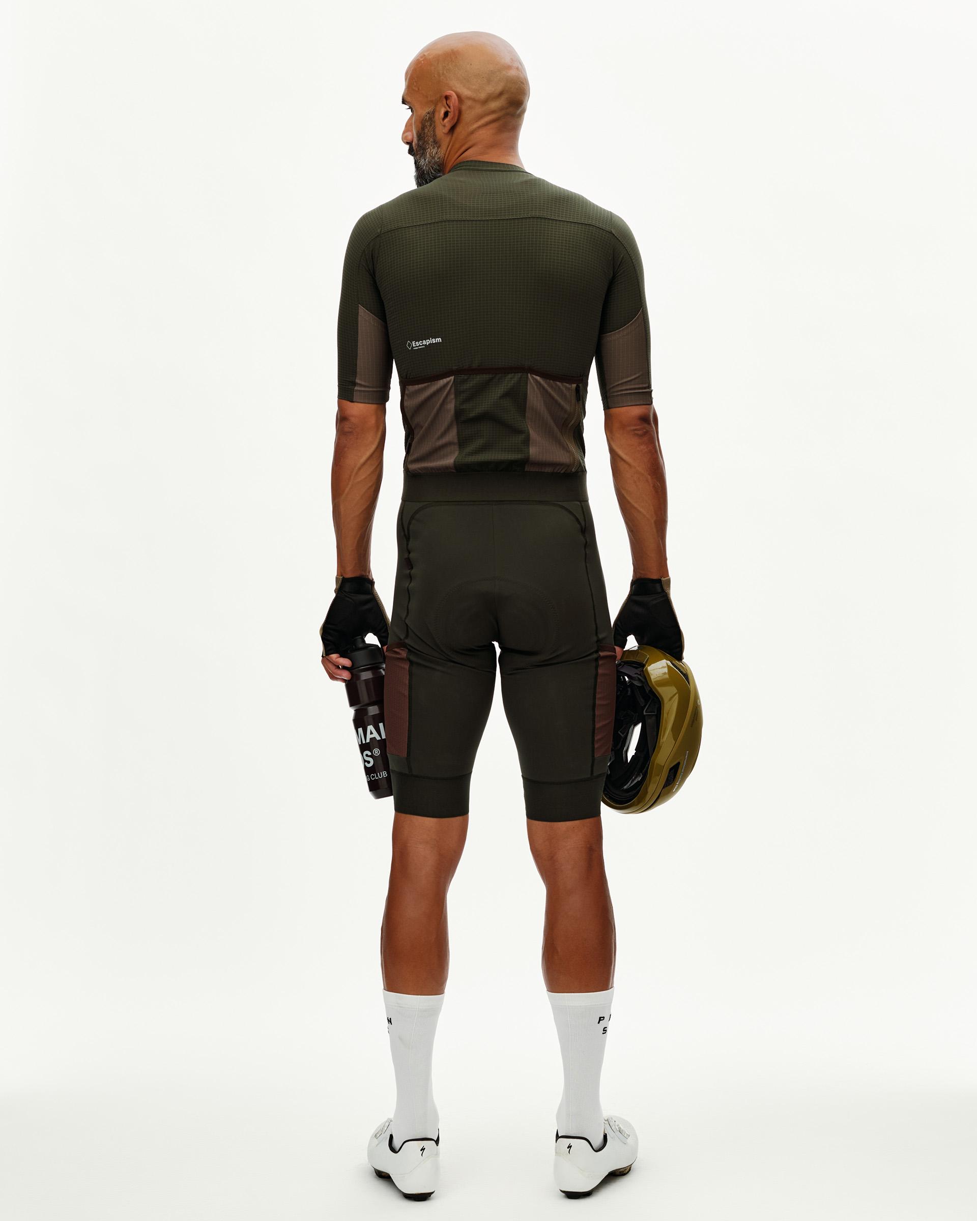 Dark Olive Escapism Cargo cycling bibs on model, rear view with brown side panels