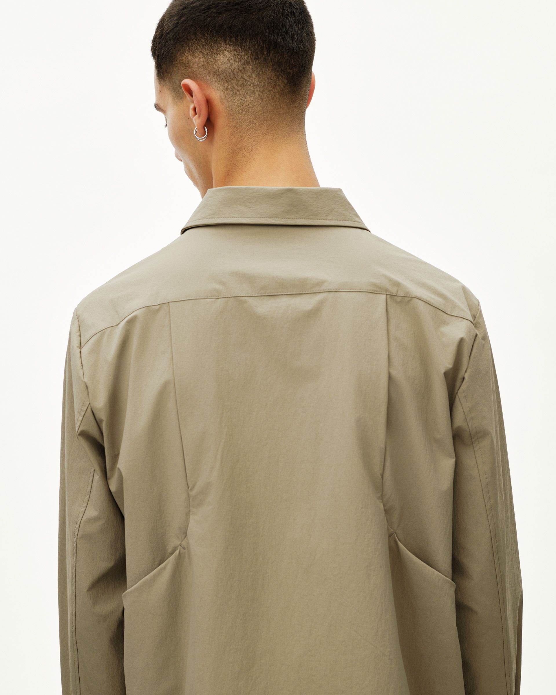 Dusty Earth khaki Off-Race Tech Overshirt on model, rear view with spread collar and panel seams