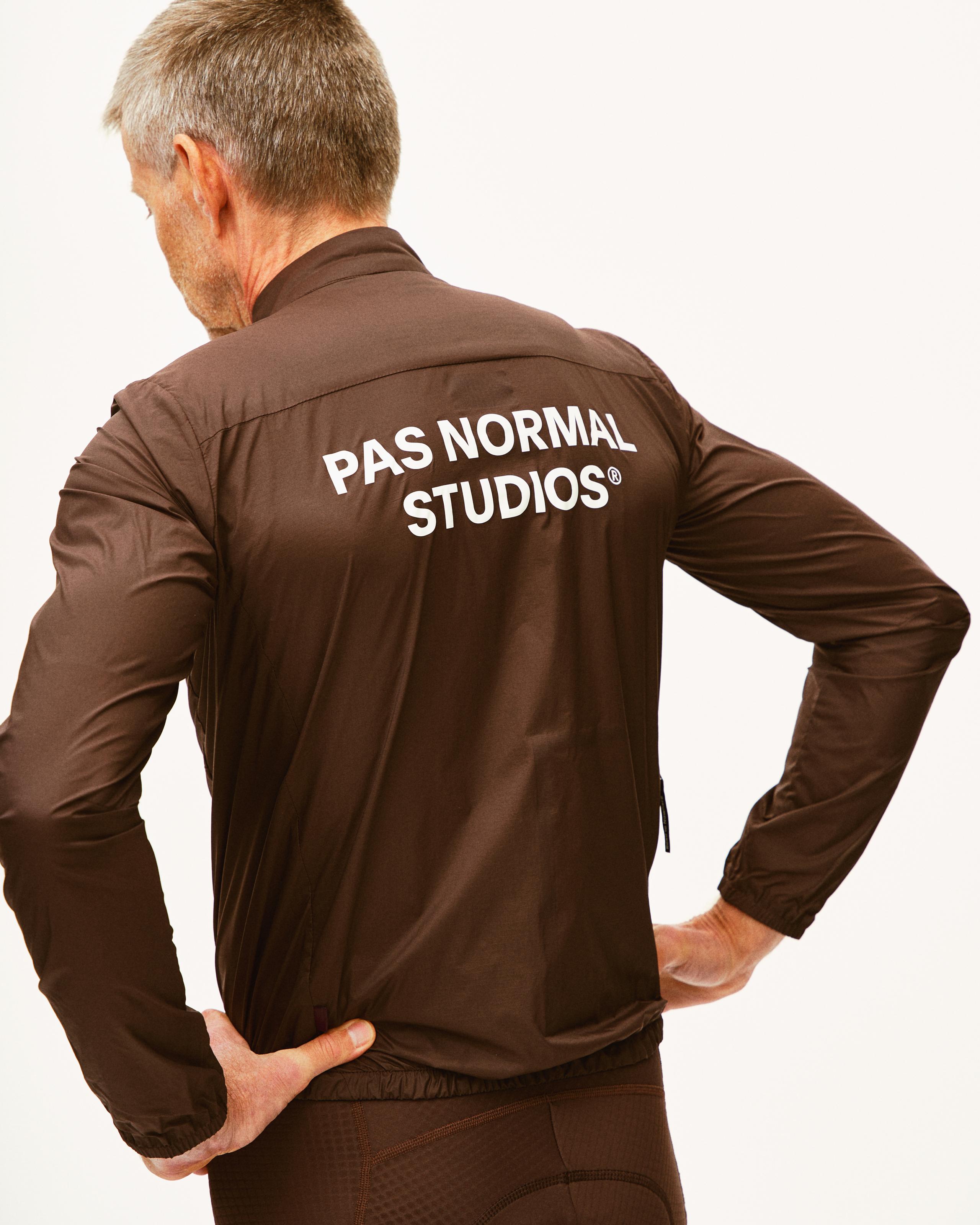 Brown Essential Insulated jacket on model, rear view with white logo print