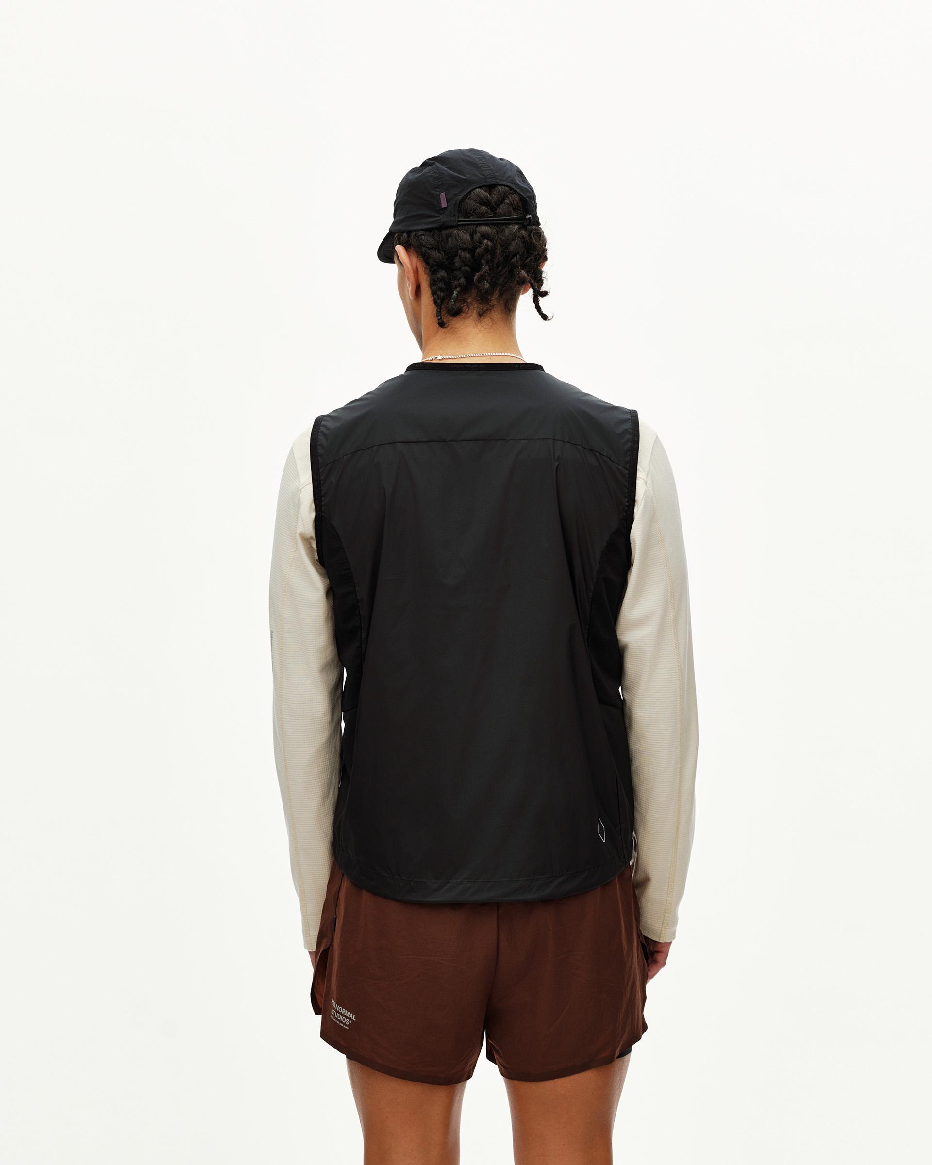 Black Balance Windproof vest on model, rear view with curved hem and small logo detail