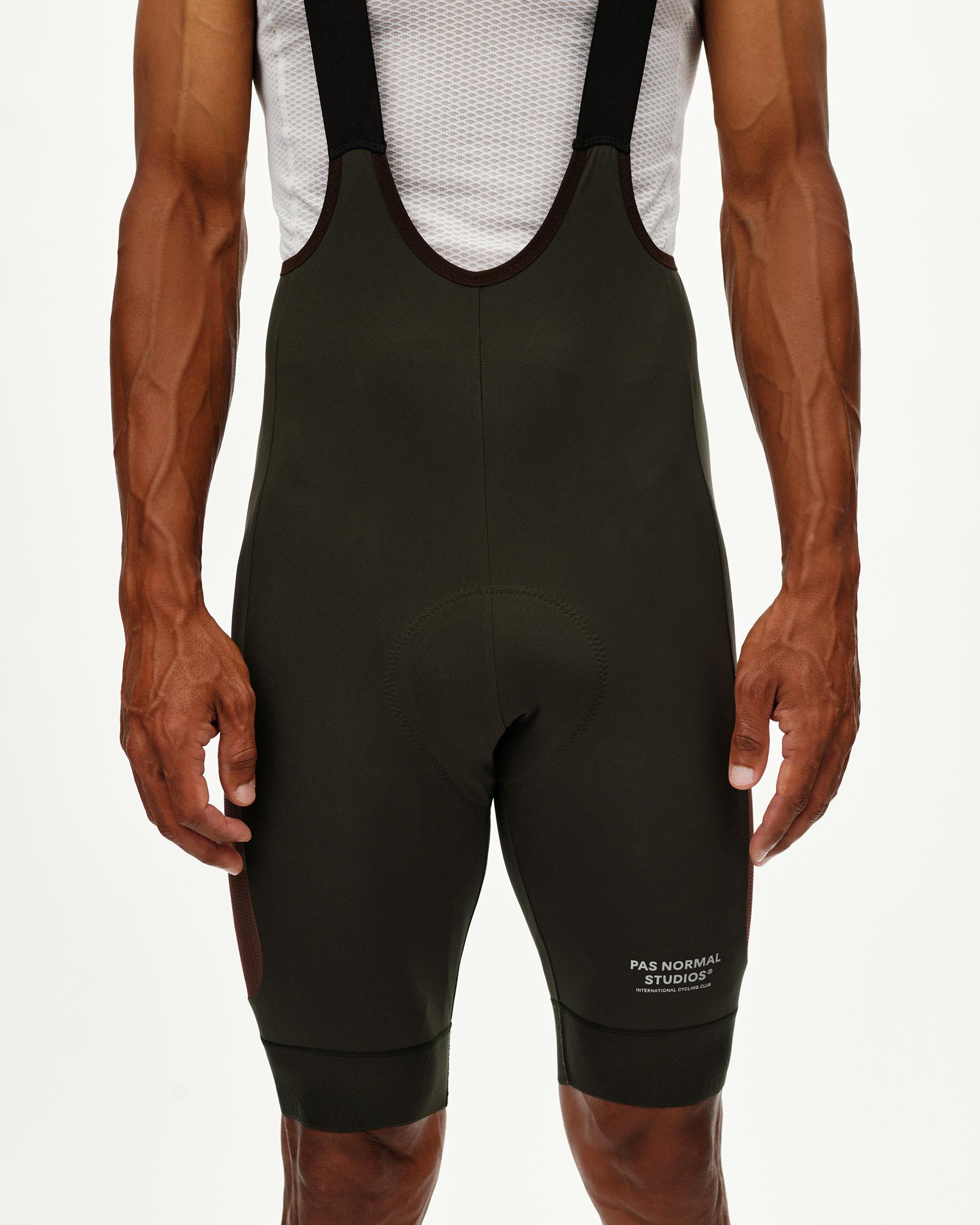Dark Olive Escapism Cargo cycling bibs on model, rear view with black straps