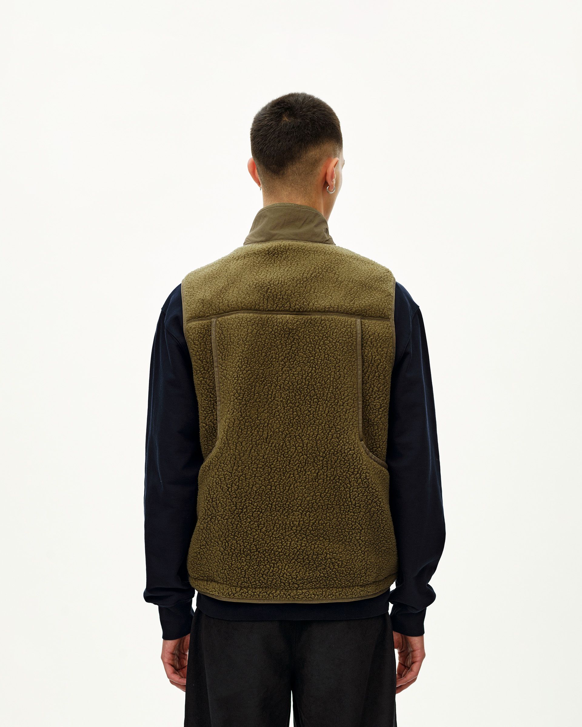 Deep Olive Off-Race Pile Fleece vest on model, rear view with sherpa texture and contrast collar panel