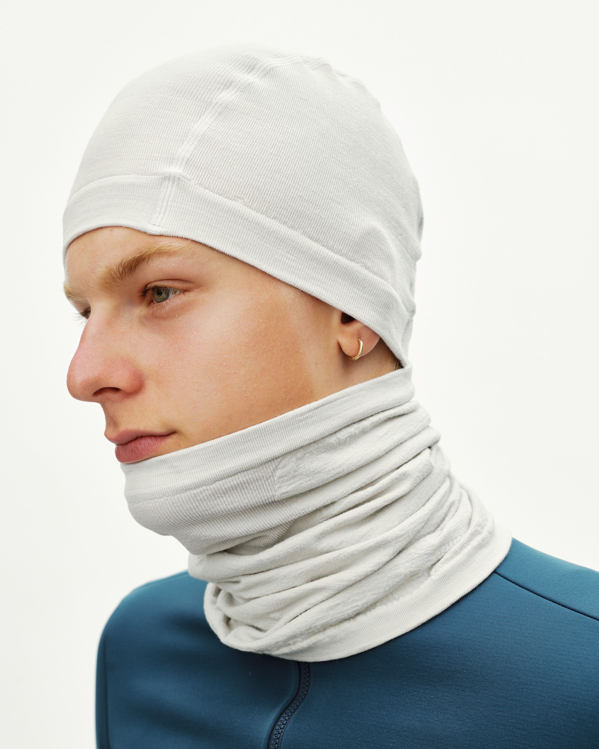 Misty Grey Logo Merino Knit cycling beanie on model, side view with matching neck warmer