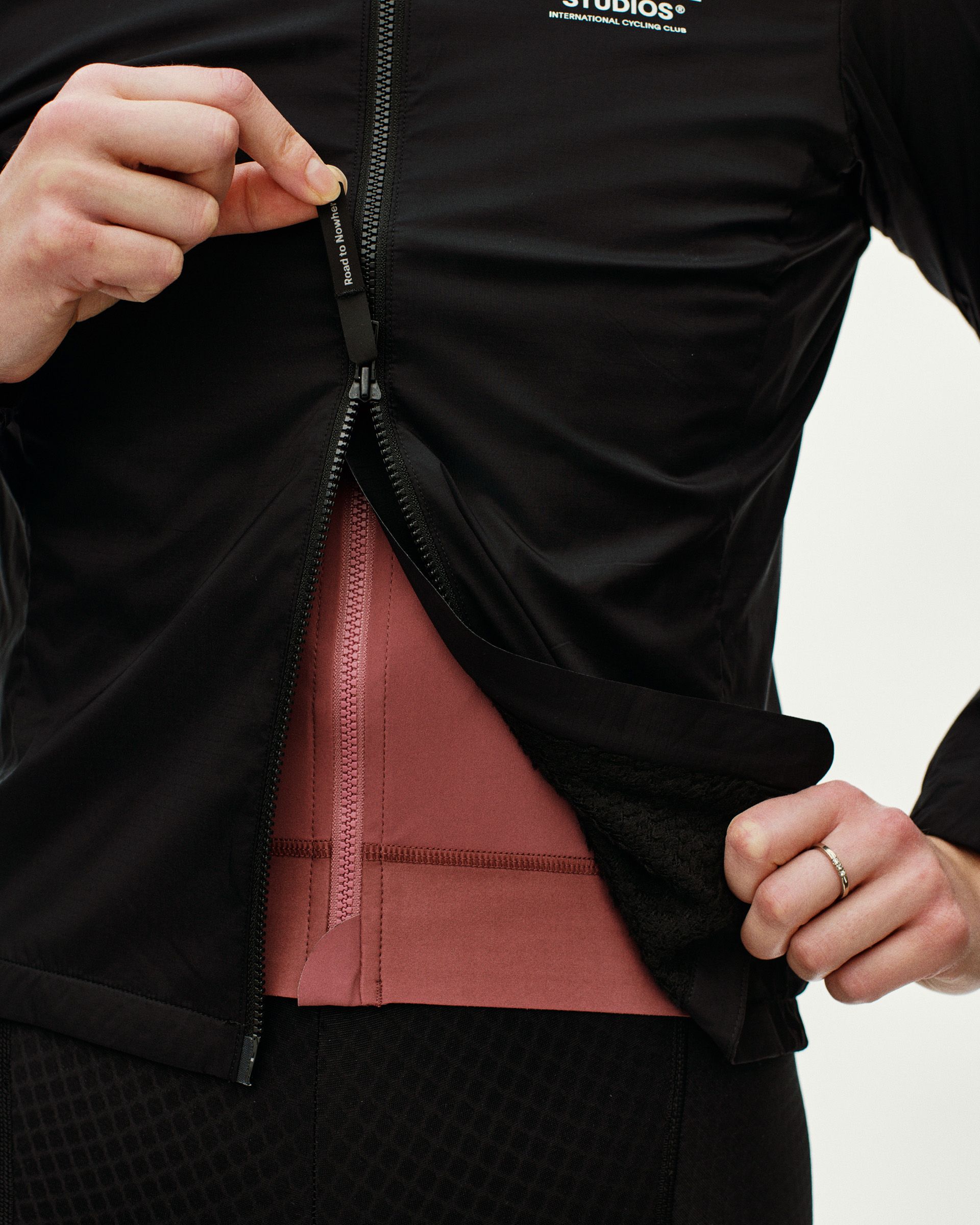 Black Essential Insulated cycling jacket on model with open zip revealing red inner layer
