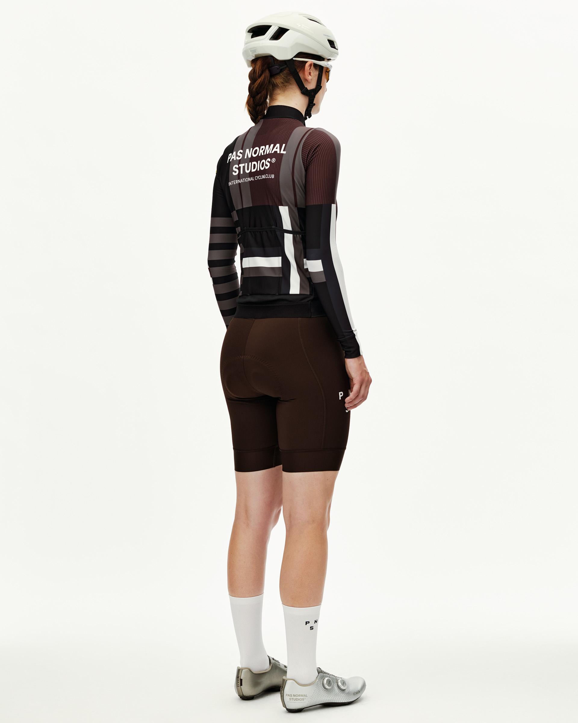 Dark Olive Mechanism women's long sleeve cycling jersey on model, rear view with striped graphic and white back print