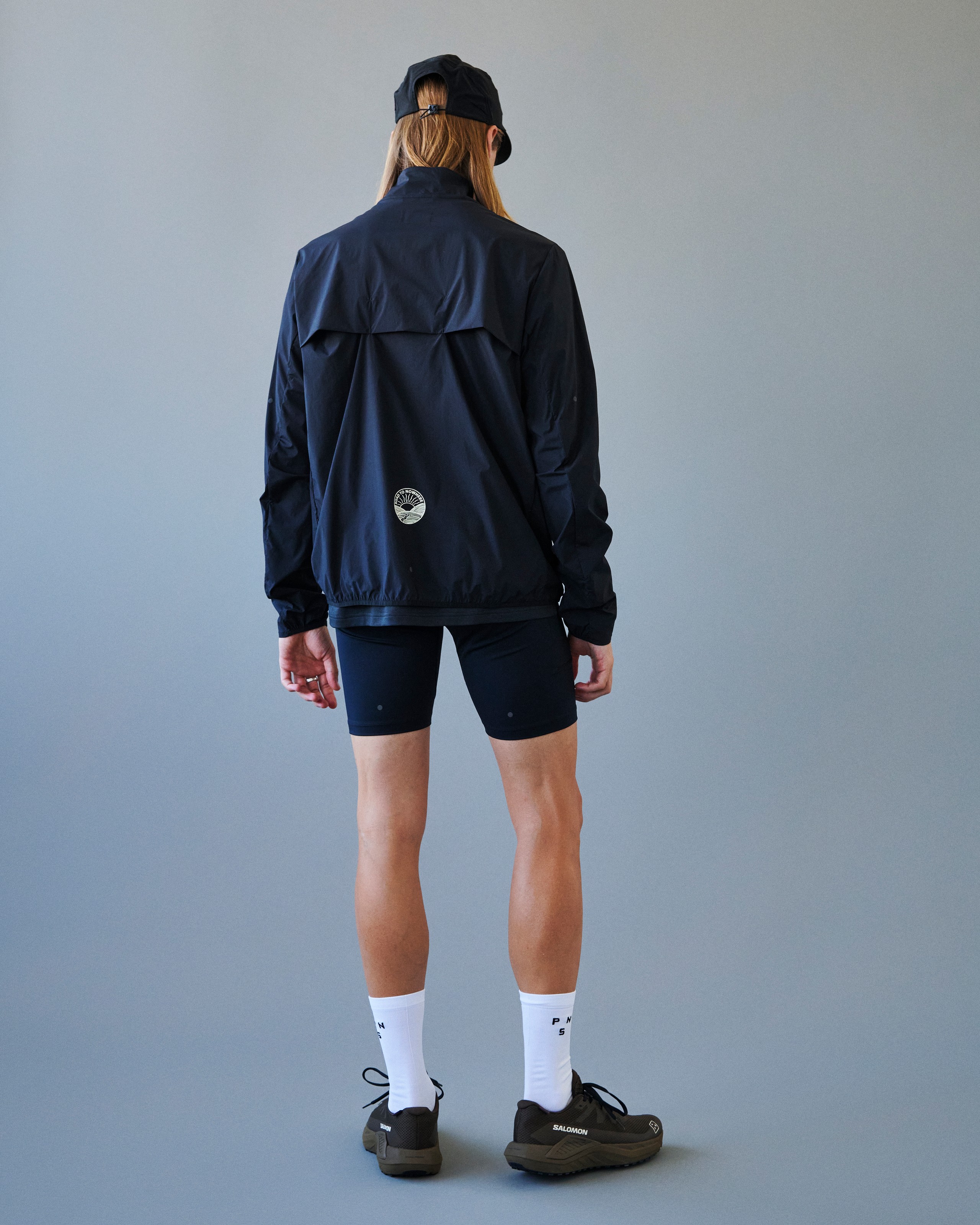 Navy Balance Half Zip cycling jacket on model, rear view with white logo