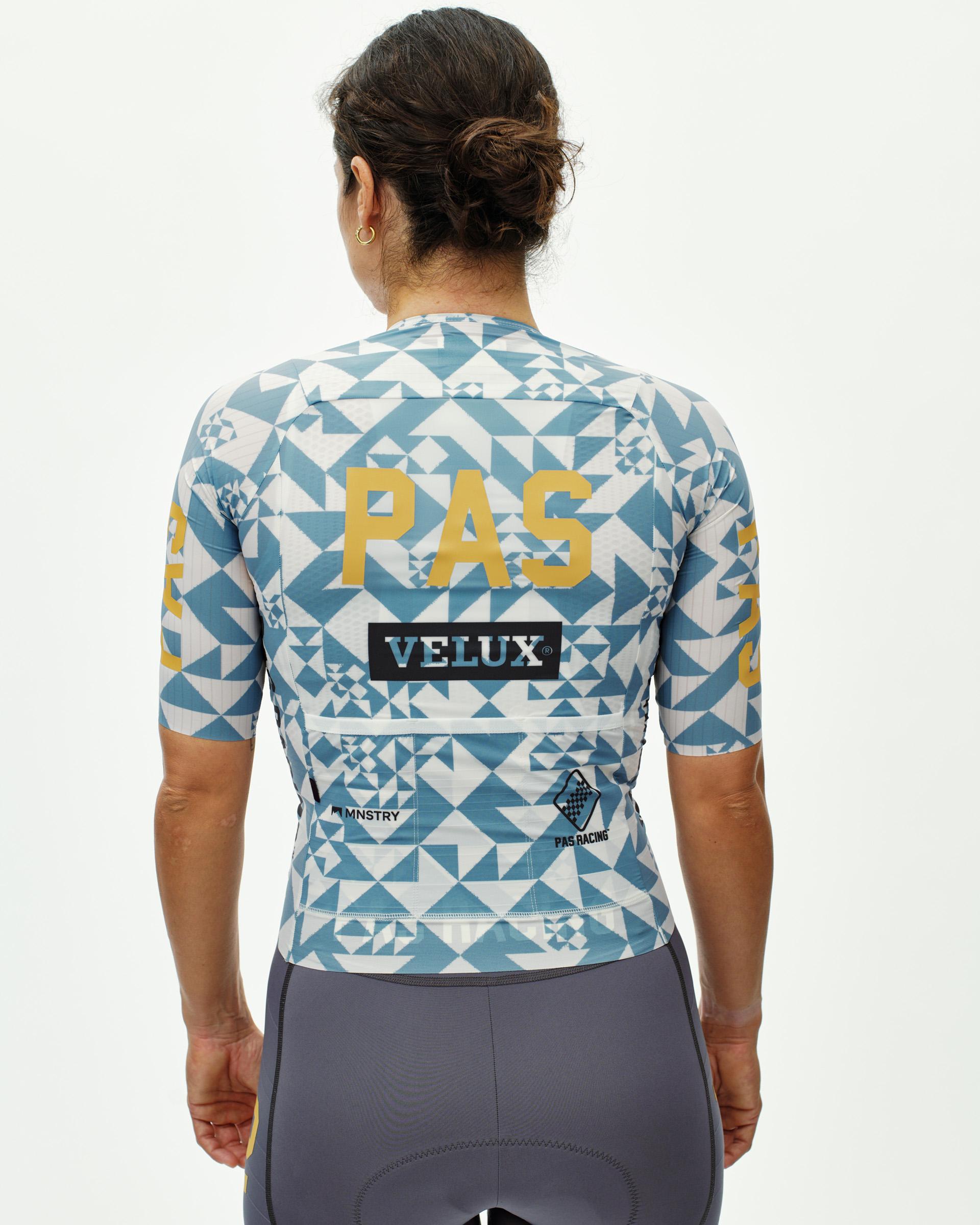 Origami Light Blue PAS Mechanism Pro women's cycling jersey, rear view on model with geometric print and gold PAS back panel