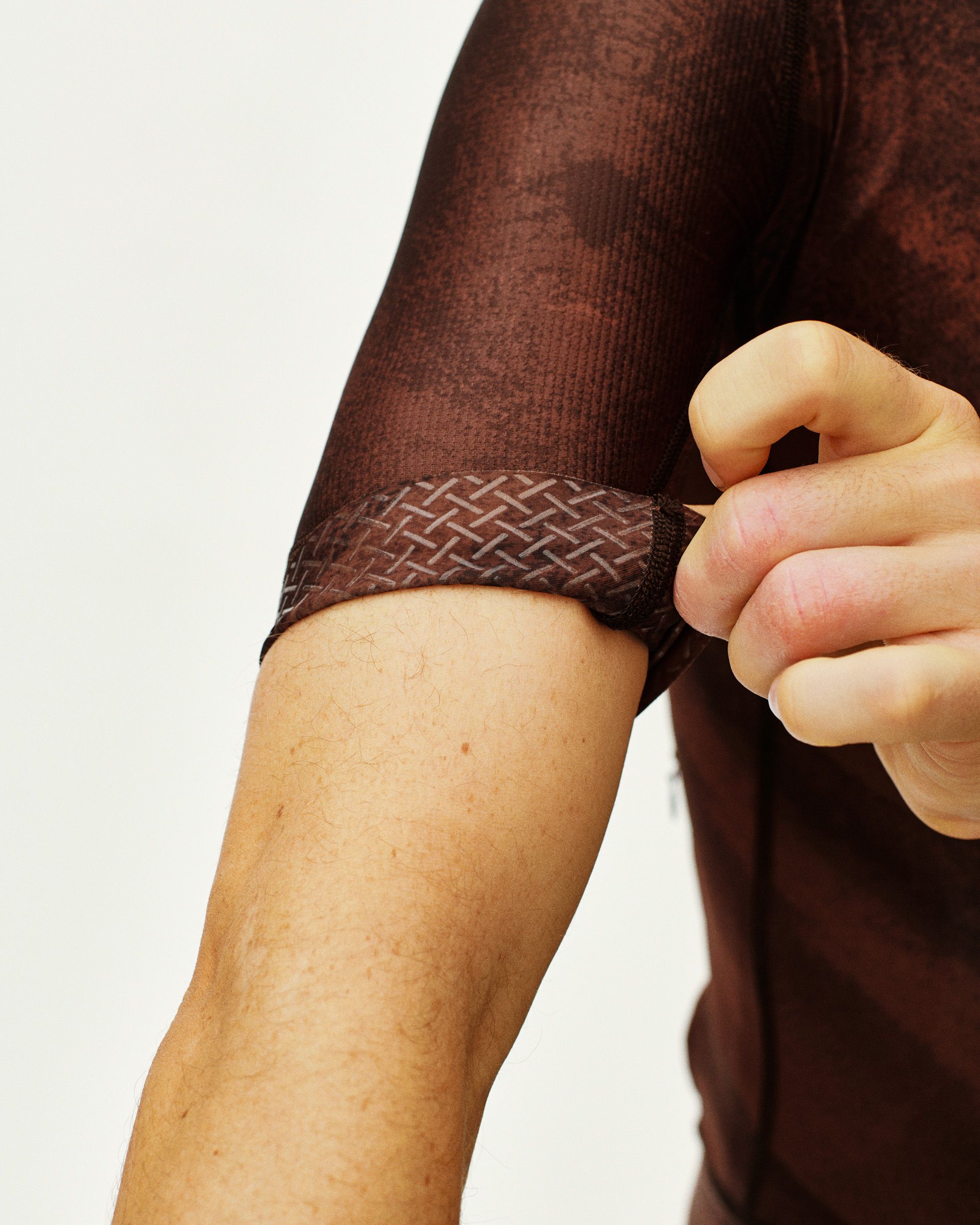 Light Brown Mechanism cycling jersey on model showing geometric pattern cuff detail