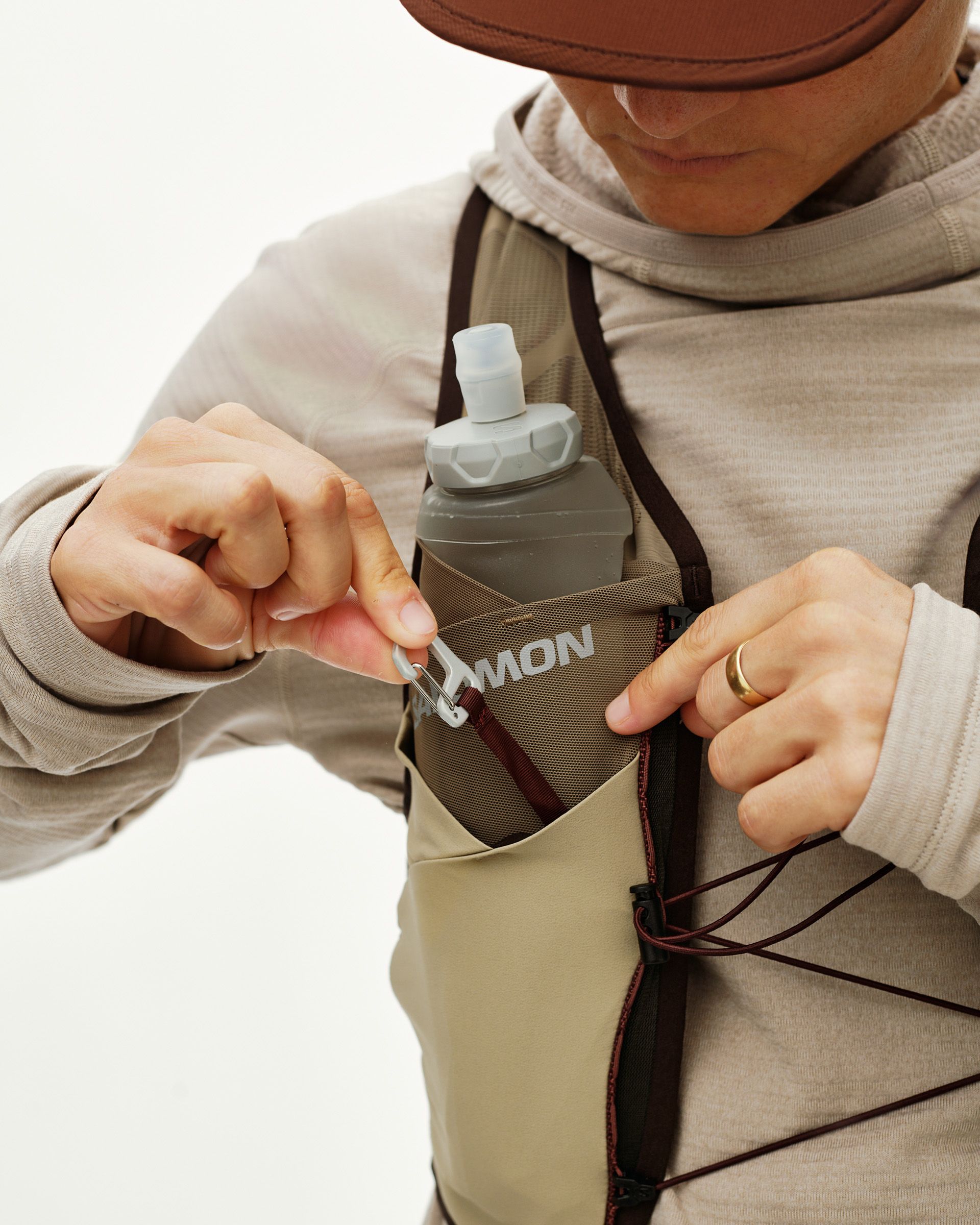 Light Brown Salomon Gravel Concept Skin 2 vest on model, detail view with soft flask in chest pocket