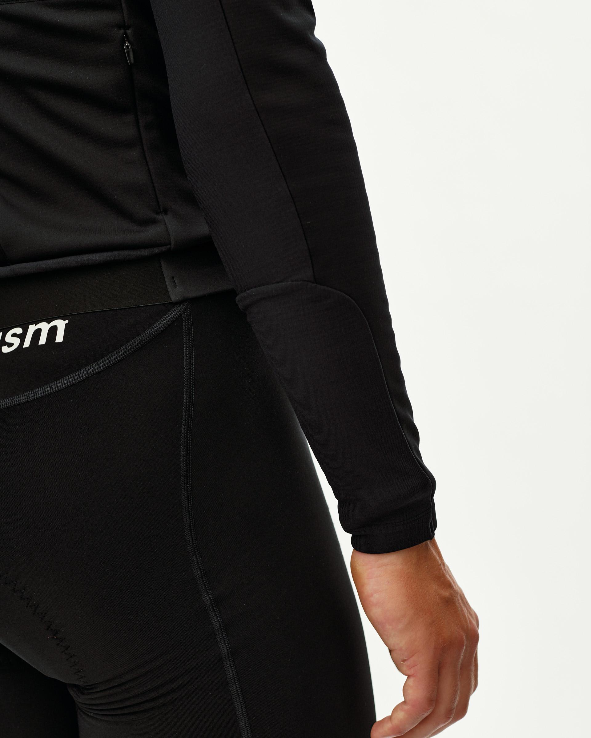 Black Mechanism Thermal Long Sleeve 2.0 cycling jersey on model, side detail view with ribbed cuff