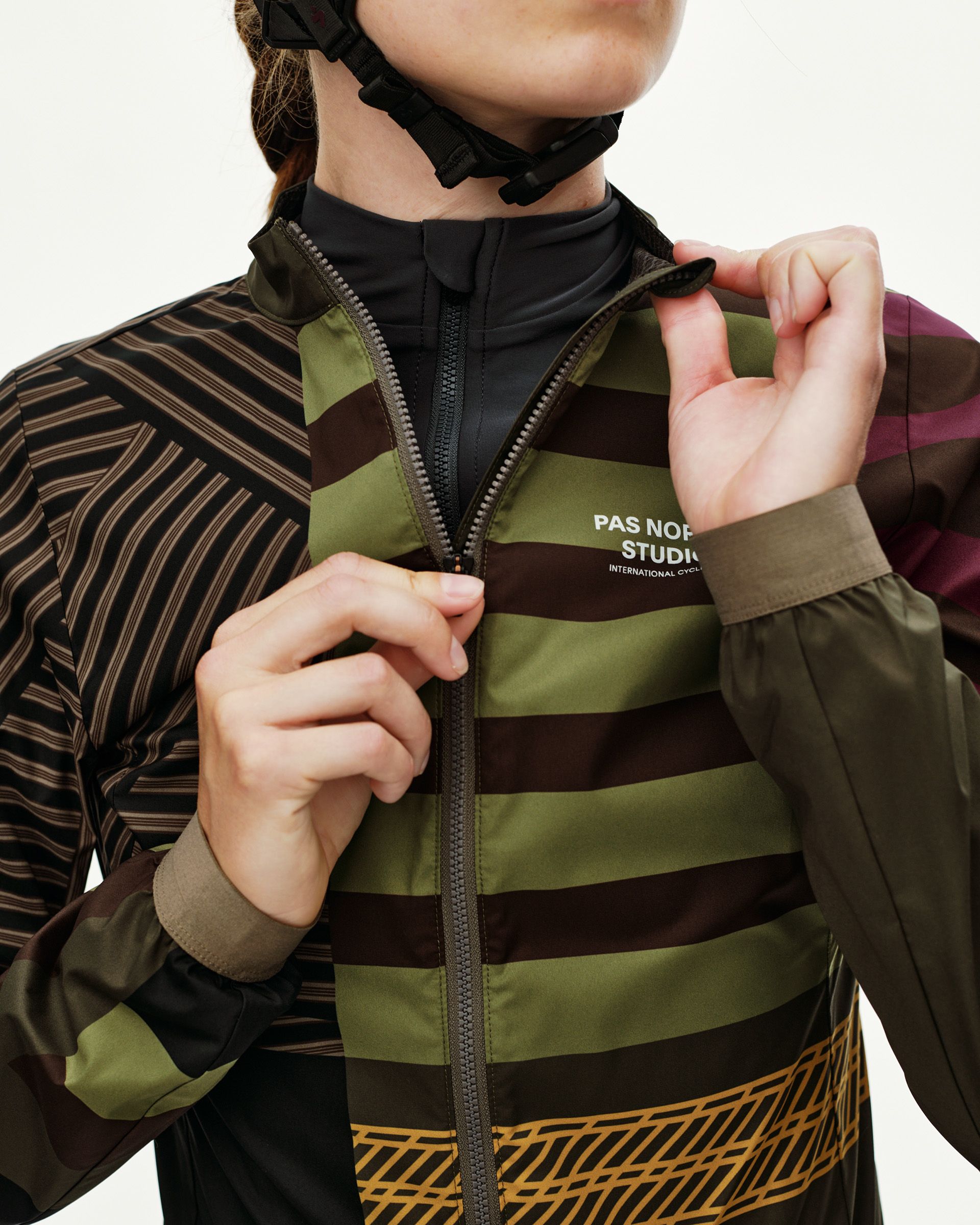 International Green Mechanism Stow Away cycling jacket on model, front detail with multicolor stripe print and full zip