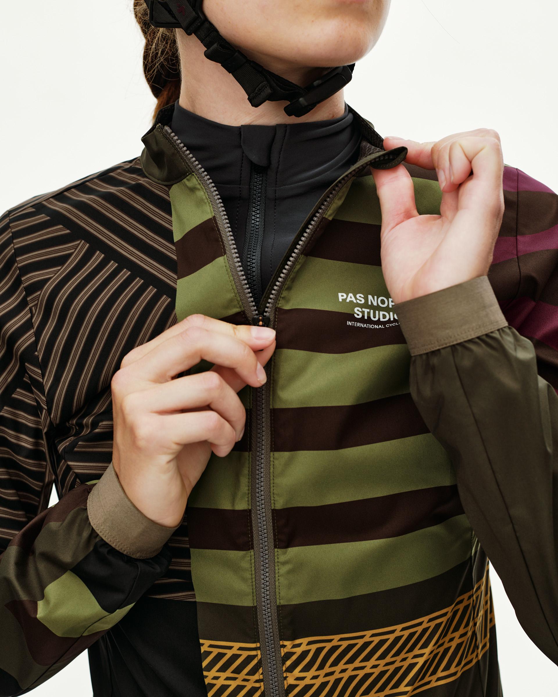 International Green Mechanism Stow Away cycling jacket on model, front detail with multicolor stripe print and full zip