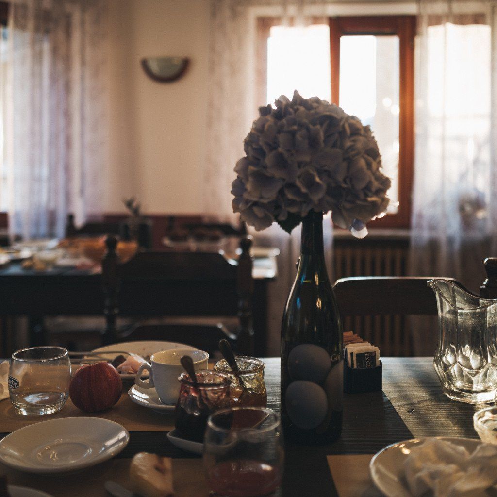 Rustic dining table with hydrangea centerpiece in sunlit interior setting