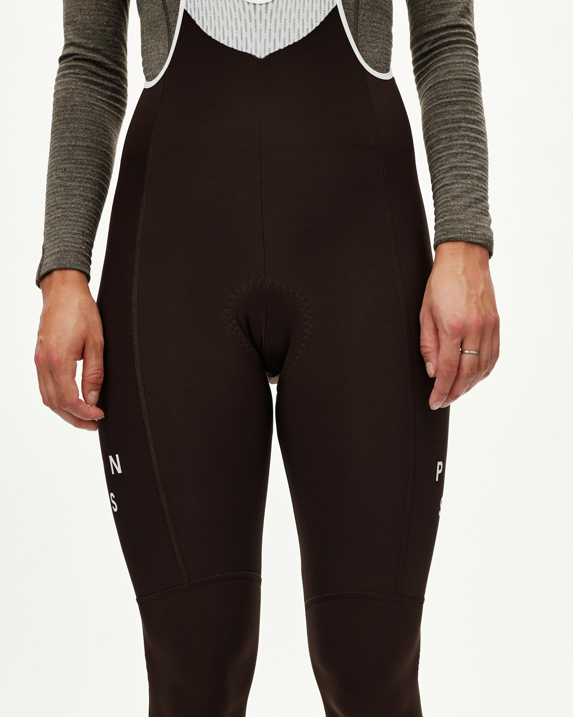 Dark Coffee brown Mechanism women's thermal cycling bib tights, front view on model with white leg text