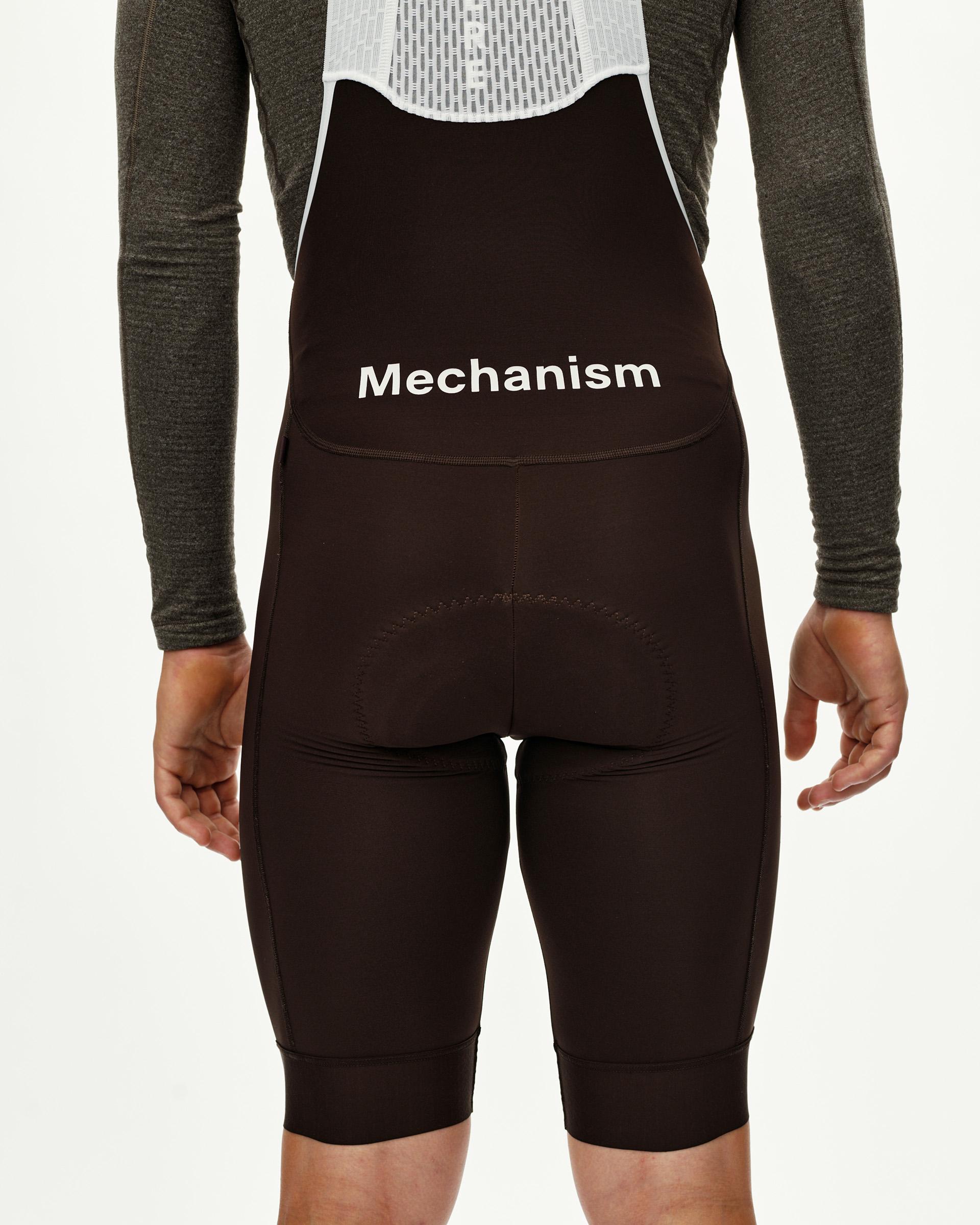 Dark Coffee Mechanism Thermal cycling bibs on model, rear view with white logo print and rear pocket