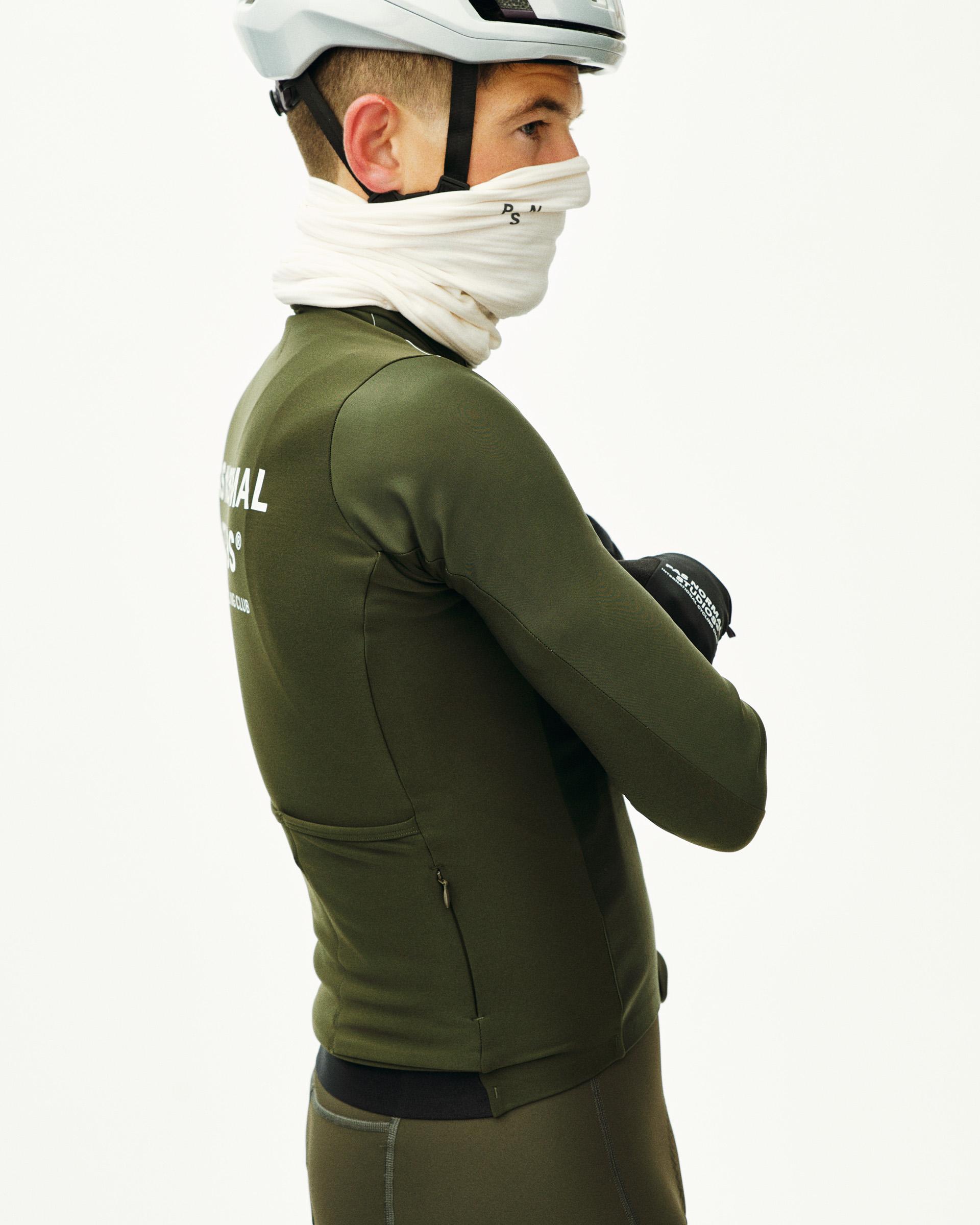 Dark Olive Mechanism Thermal long sleeve cycling jersey on model side view with white chest print