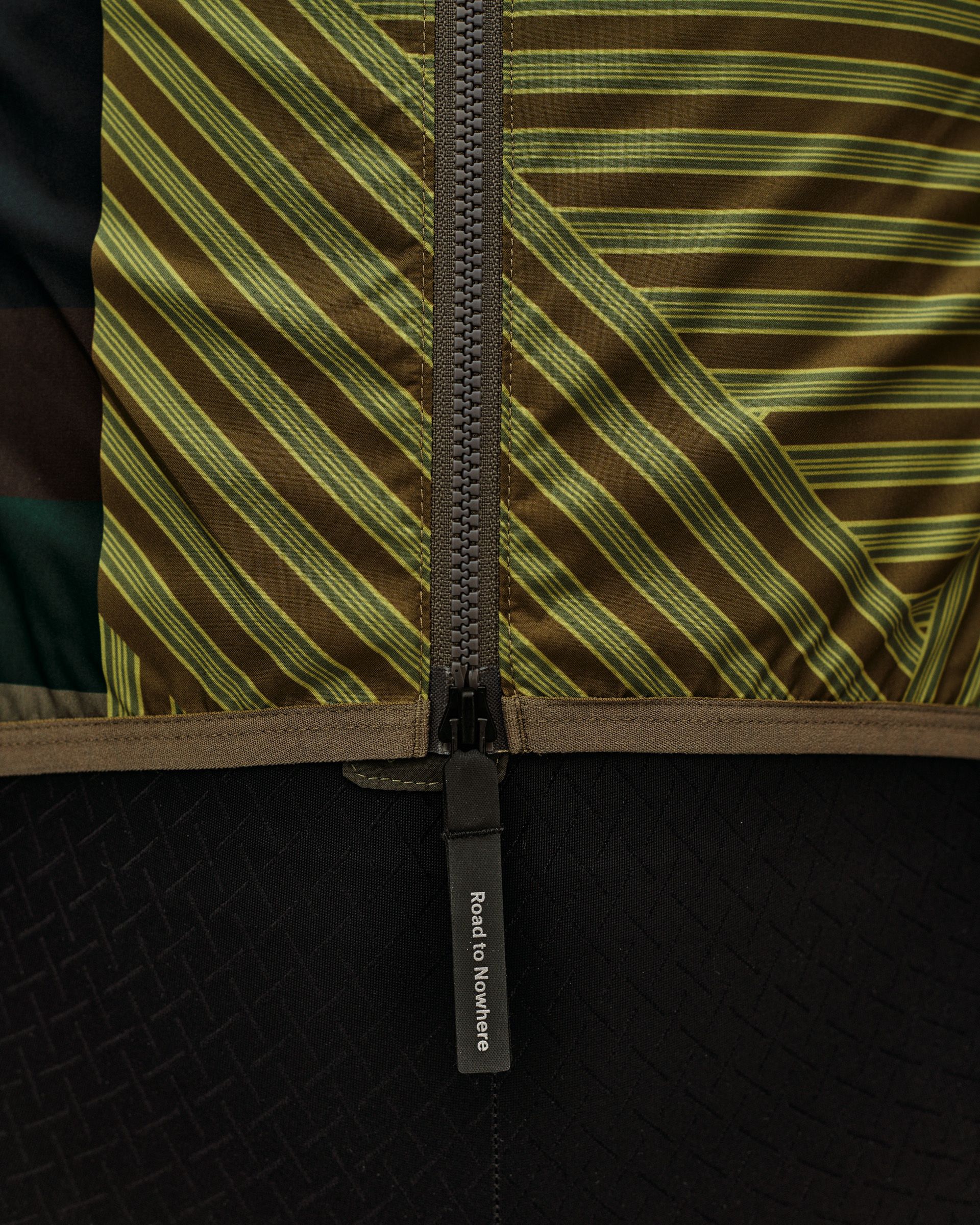 International Earth khaki Mechanism Stow Away cycling gilet, rear detail view with full-length zip and branded zip pull