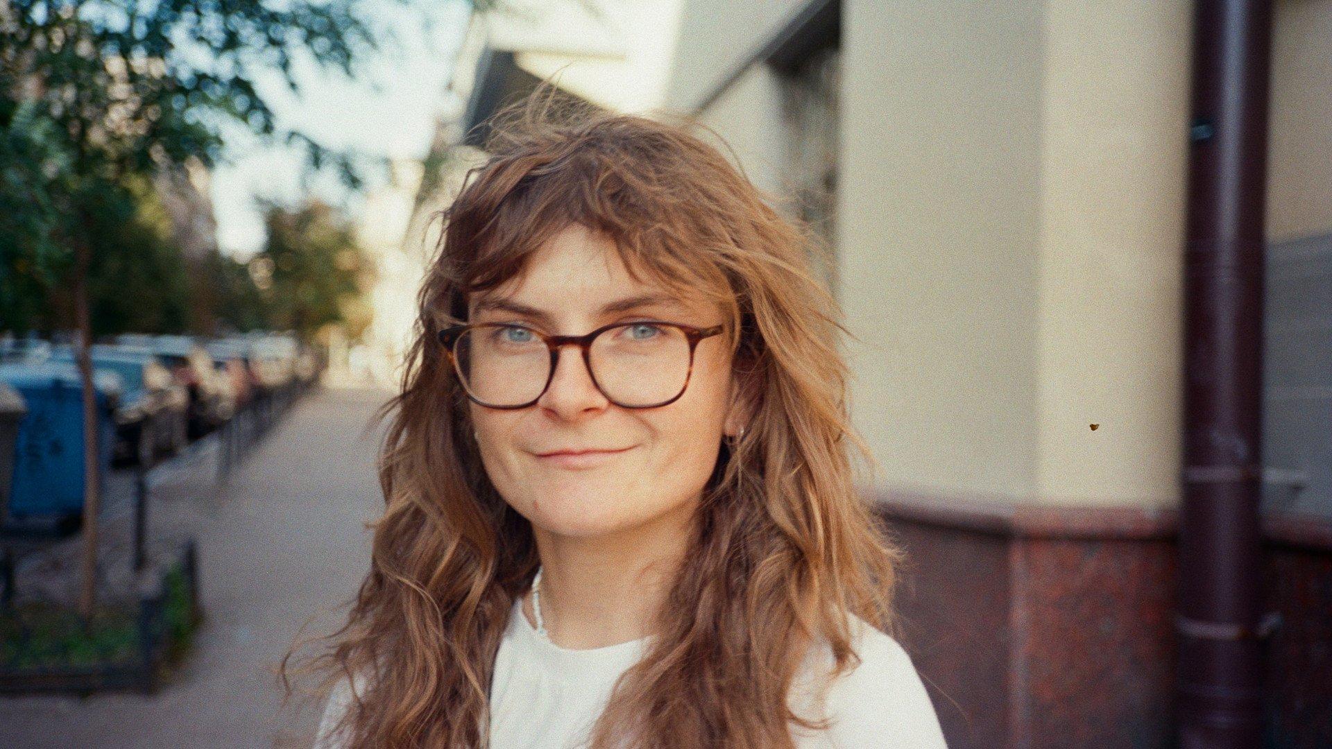 Model wearing white casual shirt with glasses outdoors