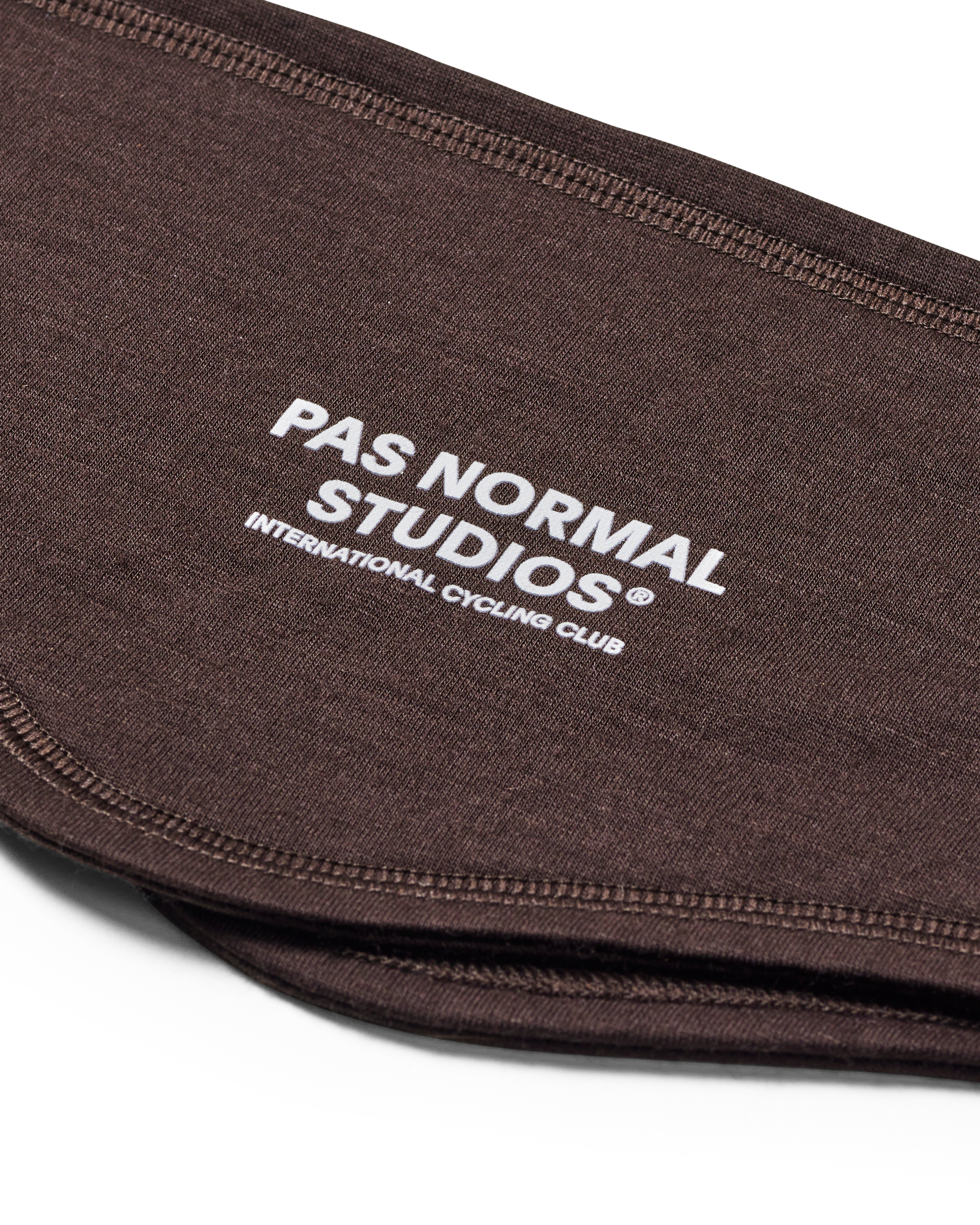 Brown Logo Merino headband, detail view with white brand text and contrast stitching