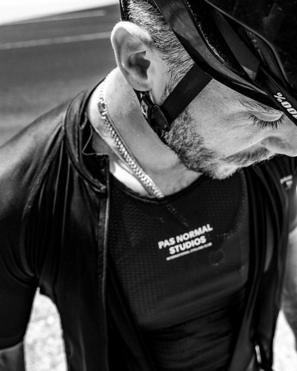 Model wearing black cycling jacket with chest branding and full zip, black and white photo
