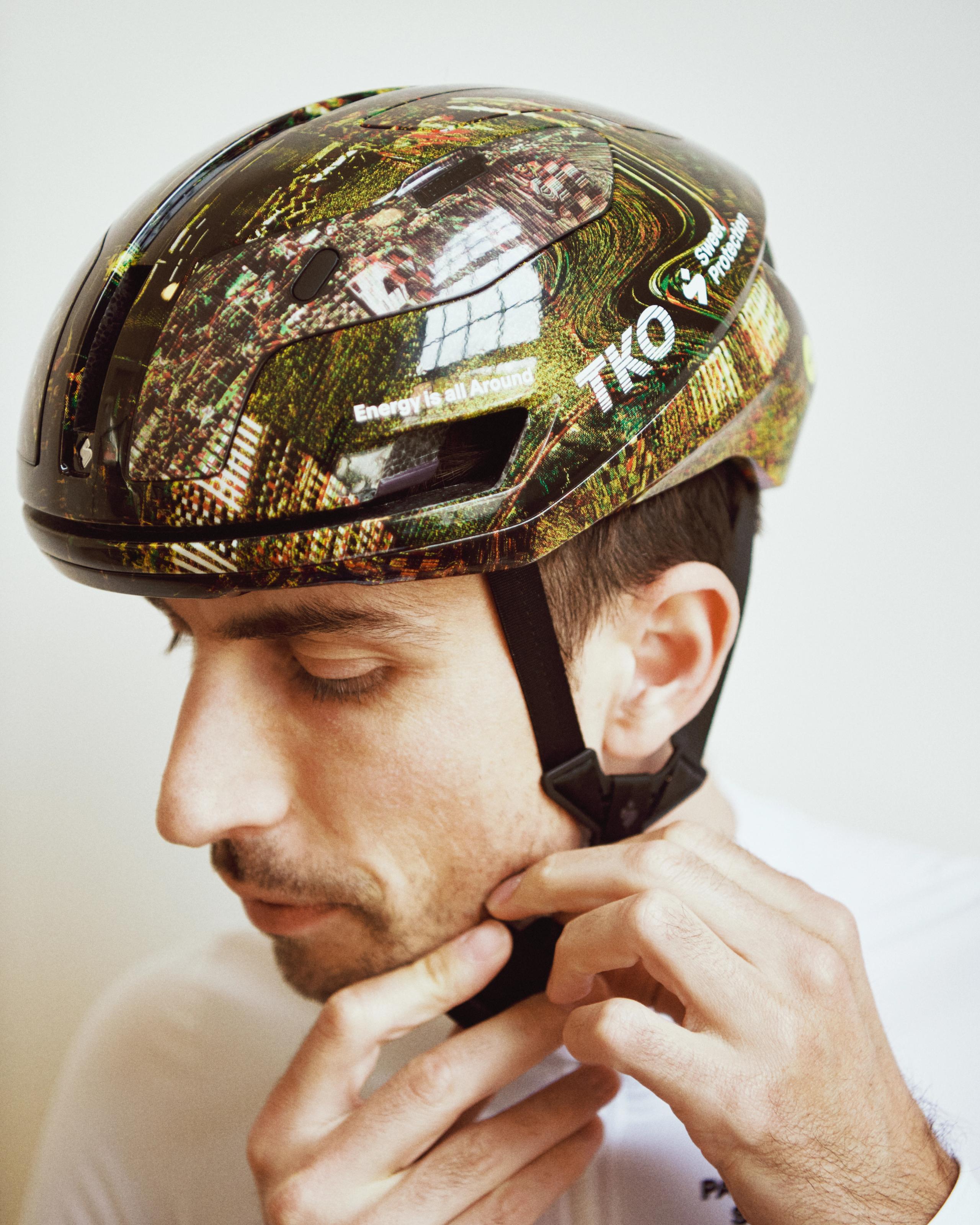 Human Error Green Sweet Protection Falconer Aero 2Vi MIPS cycling helmet on model, side view with aerial print graphic shell