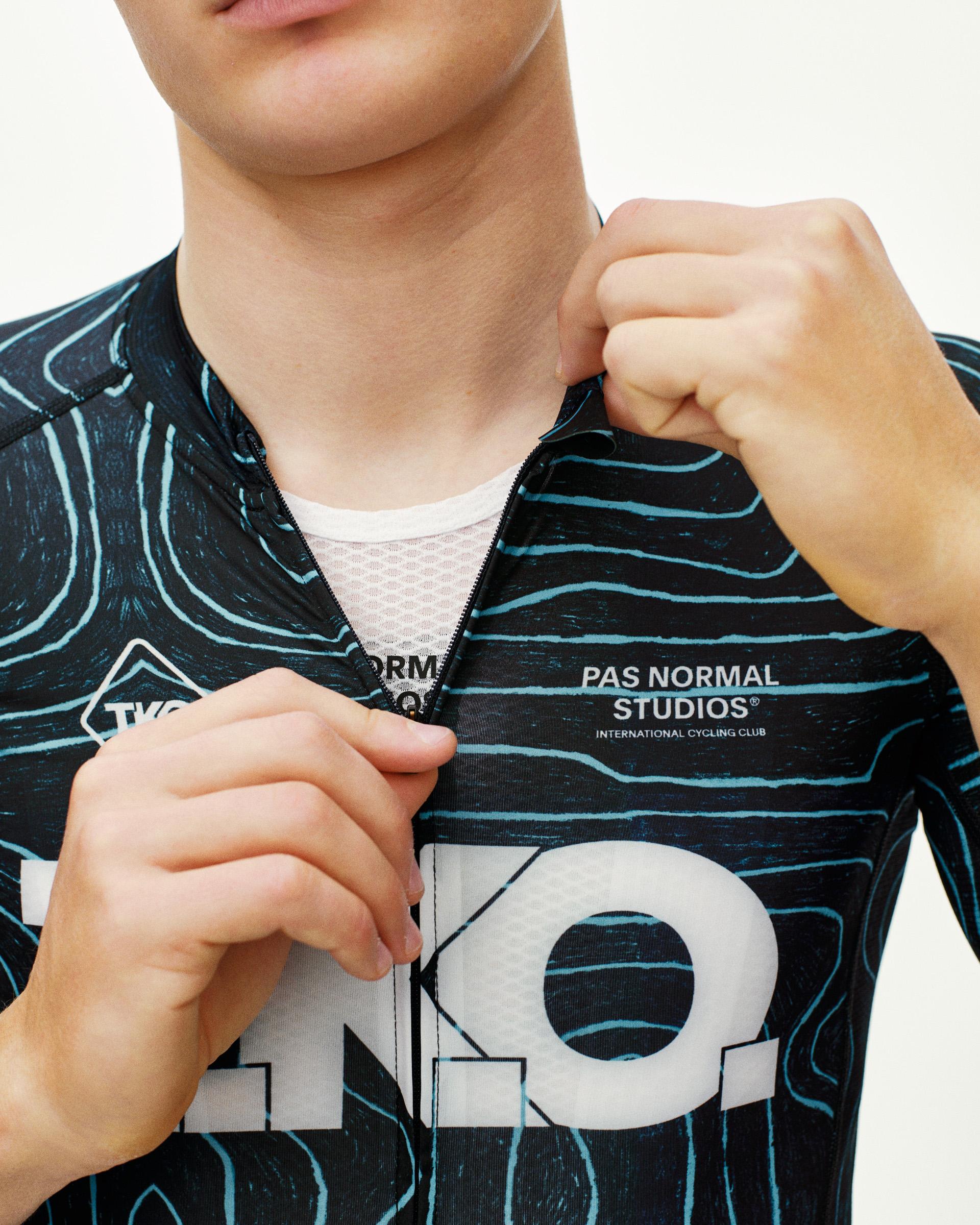 Blue T.K.O. Mechanism cycling jersey, front detail on model with topo line print and open zip