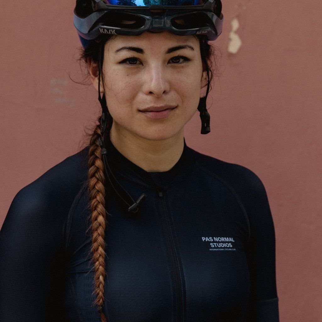 Model wearing navy blue cycling jersey with chest logo and full zip