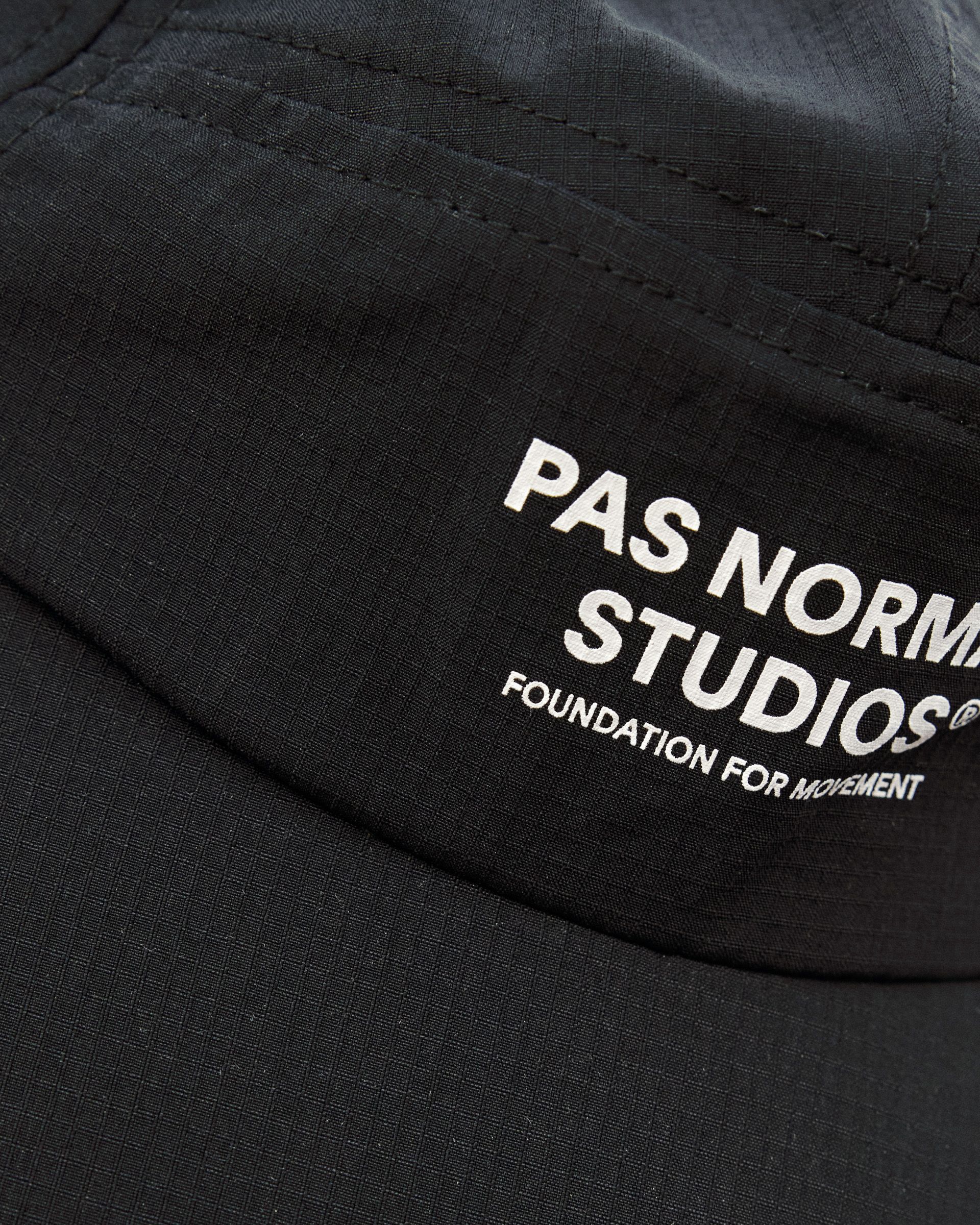 Ripstop nylon fabric with geometric grid pattern and white logo branding on black cap panel