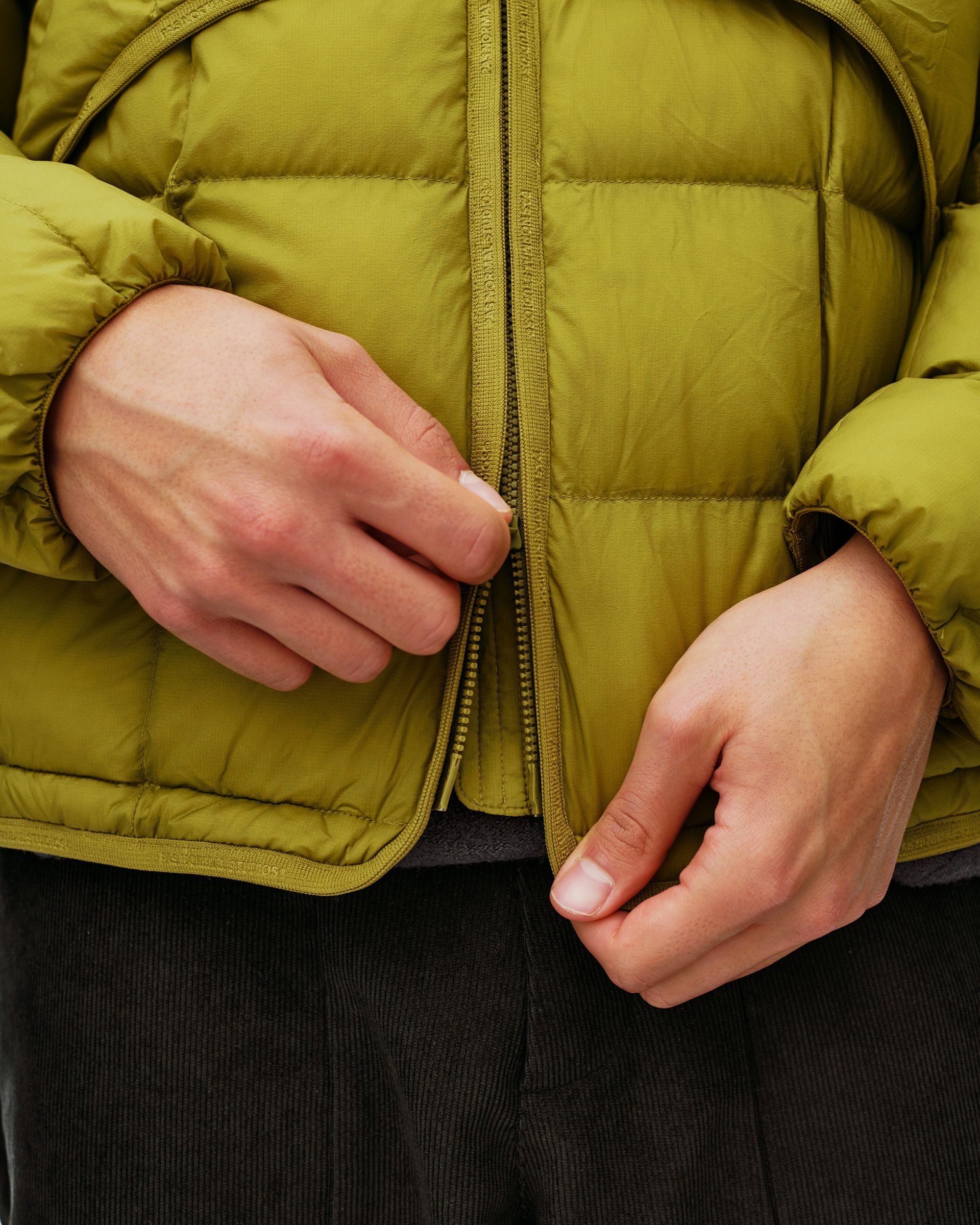 Dark Lime green Off-Race Down Liner jacket, front detail on model showing zip placket and quilted panels