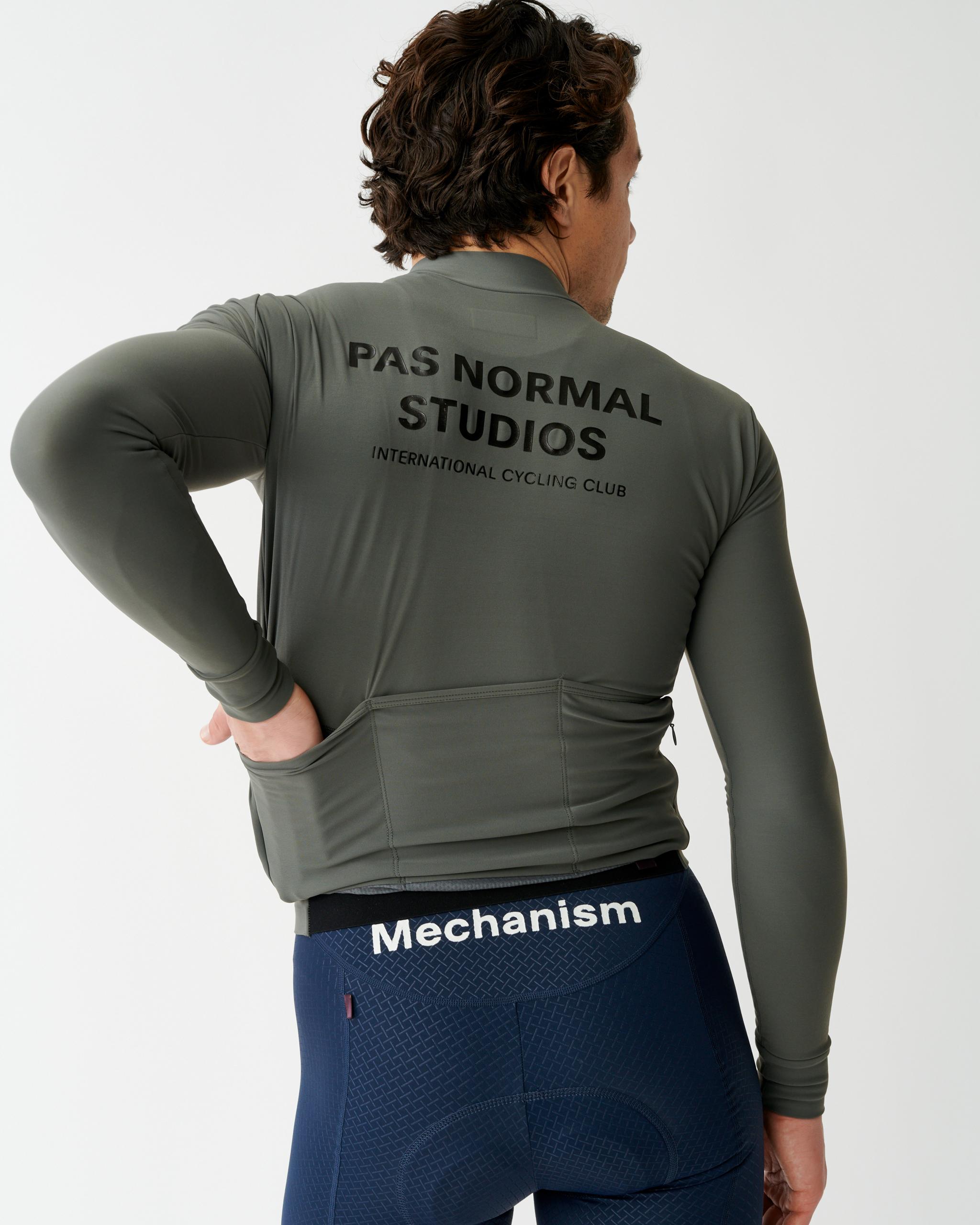 Dark Grey Mechanism long sleeve cycling jersey, rear view on model with black back print and rear pockets