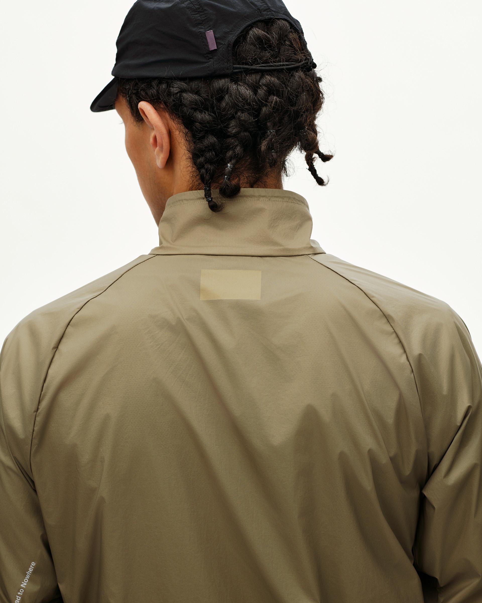 Dusty Earth khaki Balance Windproof jacket on model, rear view with tonal back label patch