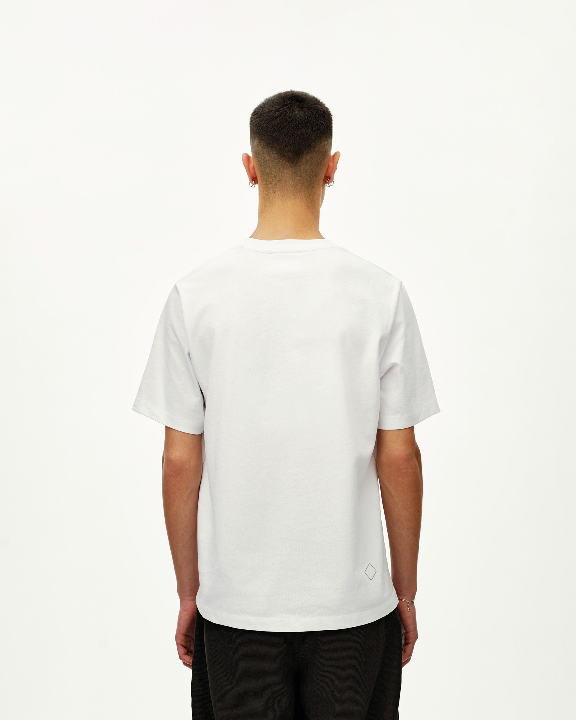 White Off-Race T-shirt on model, rear view with small diamond logo at hem