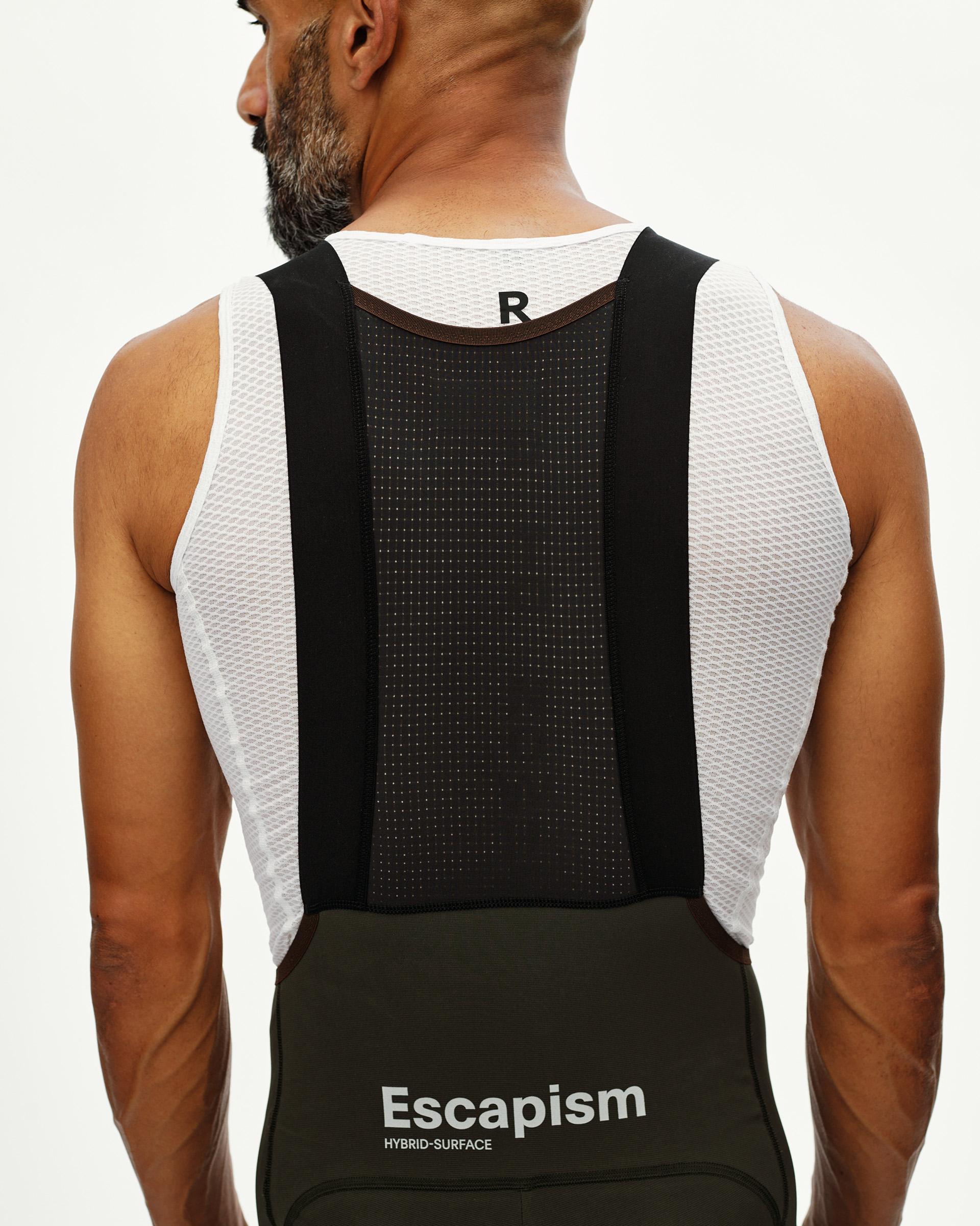 Dark Olive Escapism Cargo cycling bibs on model, rear view with mesh bib straps and logo waistband print