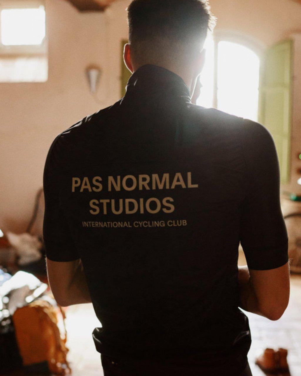 Model wearing black cycling jersey with back logo branding indoors