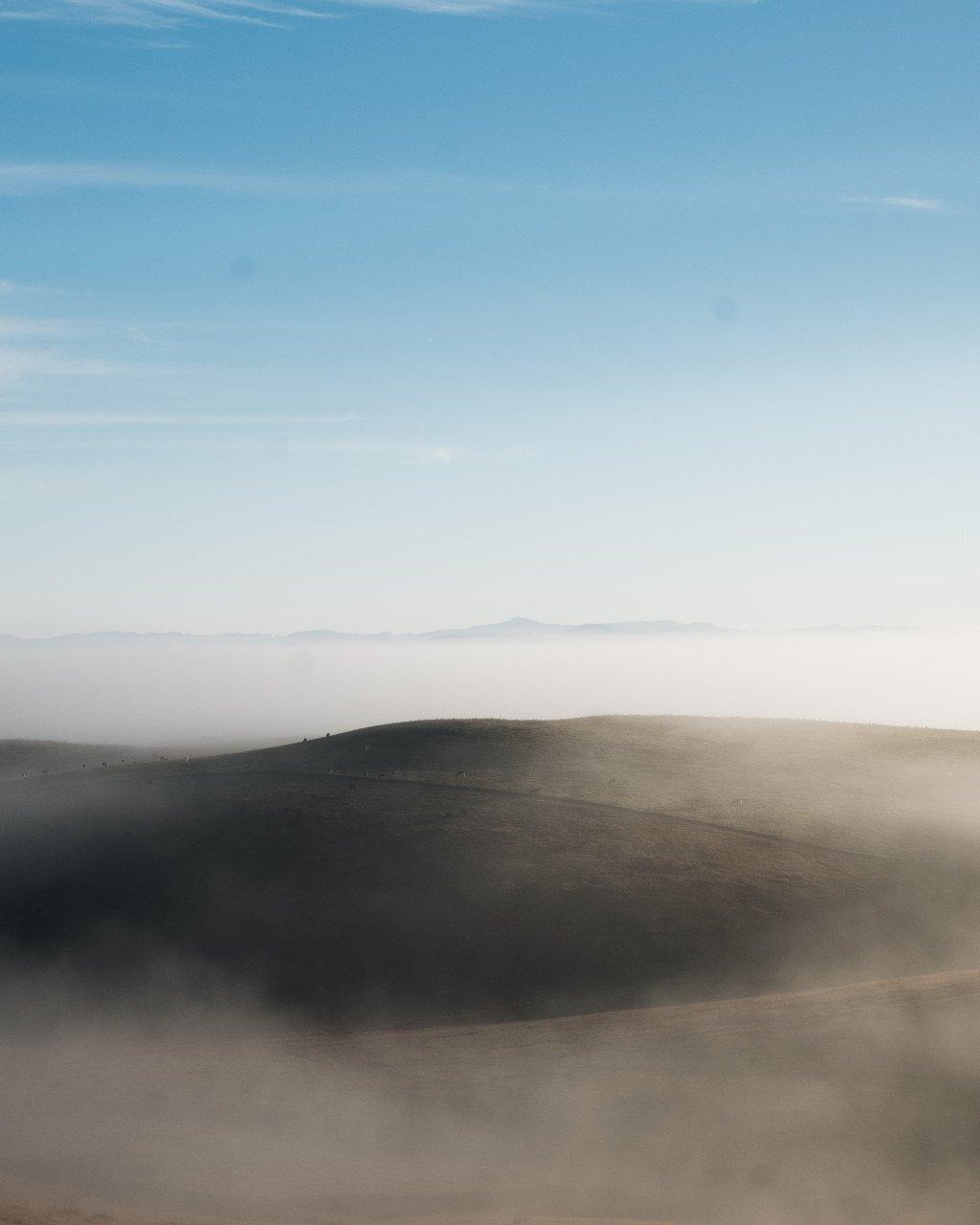 Rolling hills landscape with blue sky and soft natural lighting