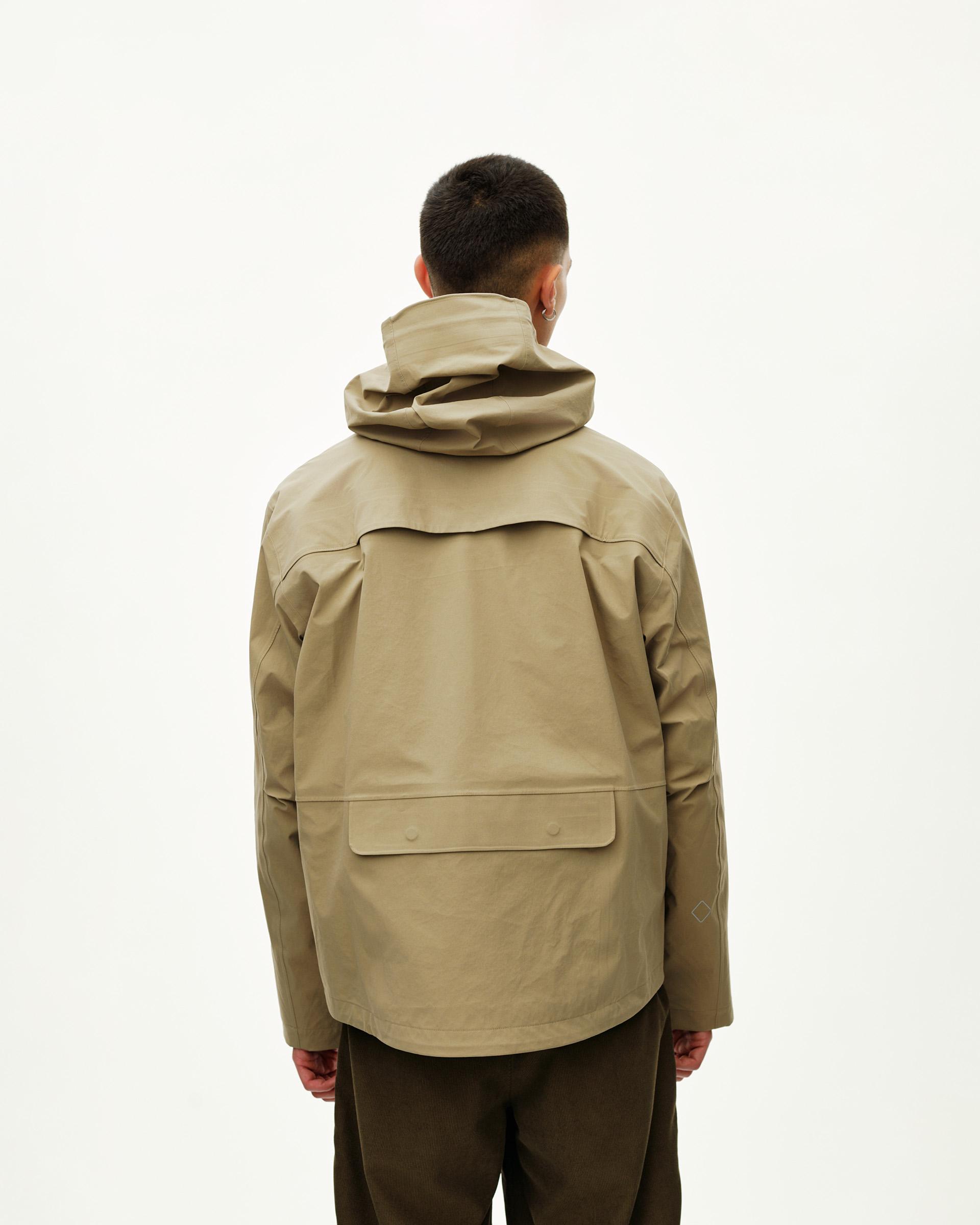 Dusty Earth khaki Off-Race 3L Shell jacket on model, rear view with large back panel pocket and storm hood