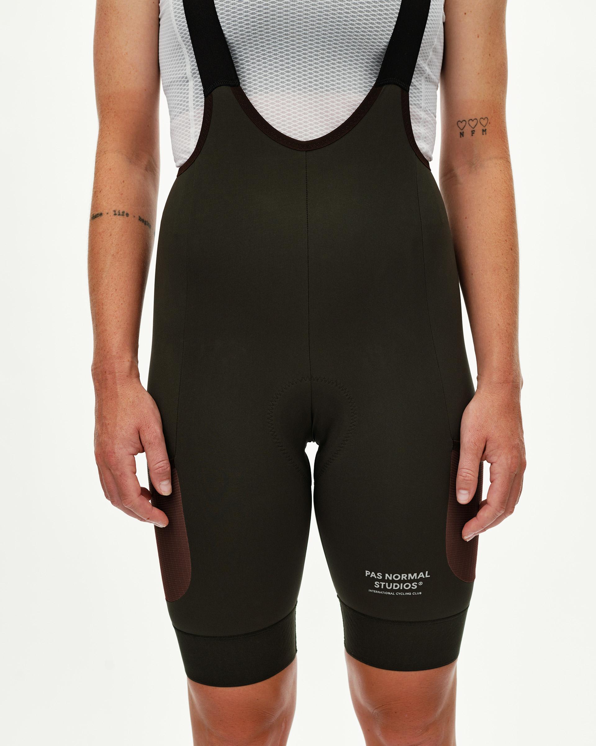 Dark Olive Escapism Cargo cycling bibs on model, front view with dark side panel inserts