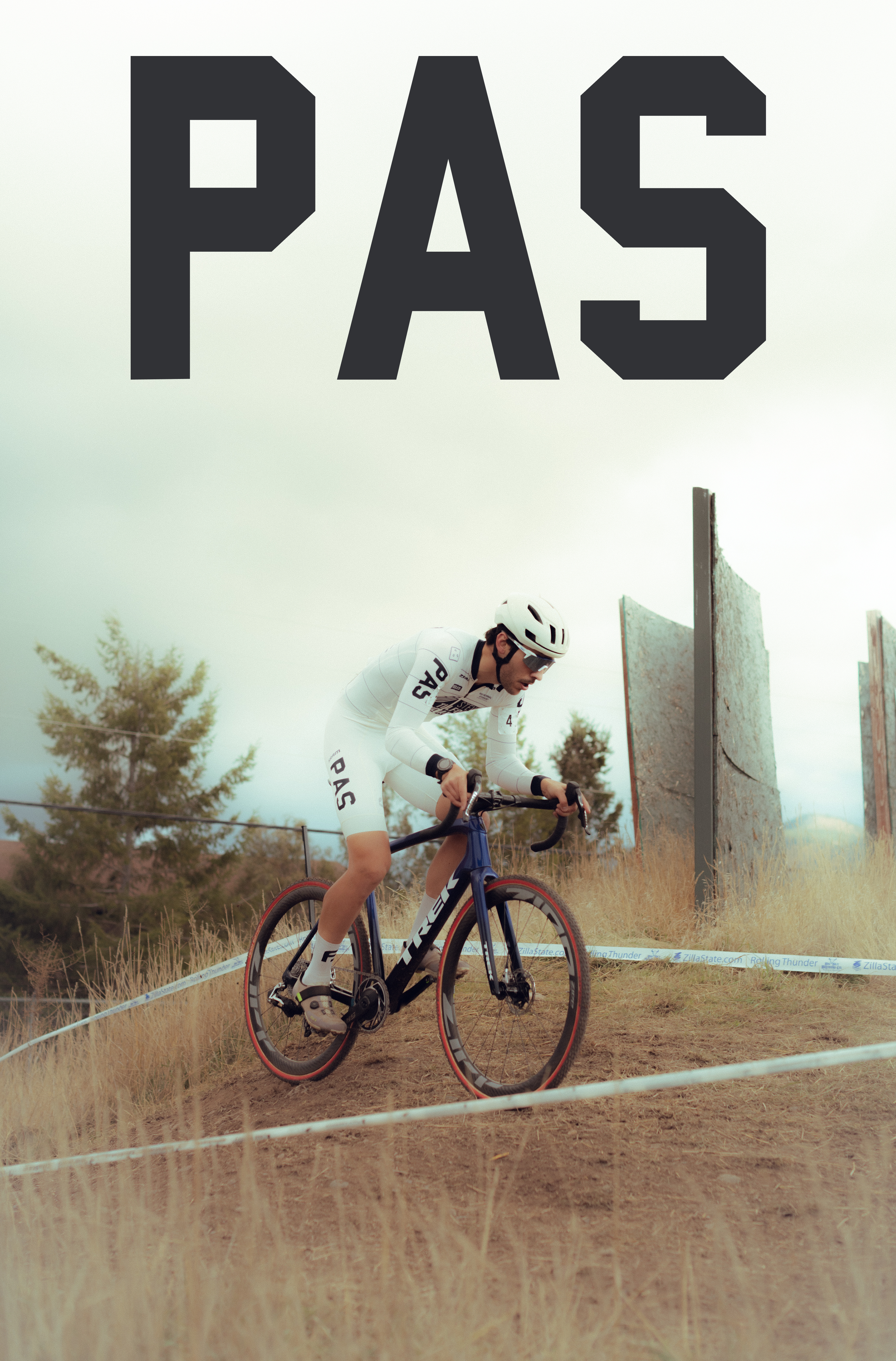 Model wearing white PAS collection cycling kit on time trial bike in aero position on dirt course