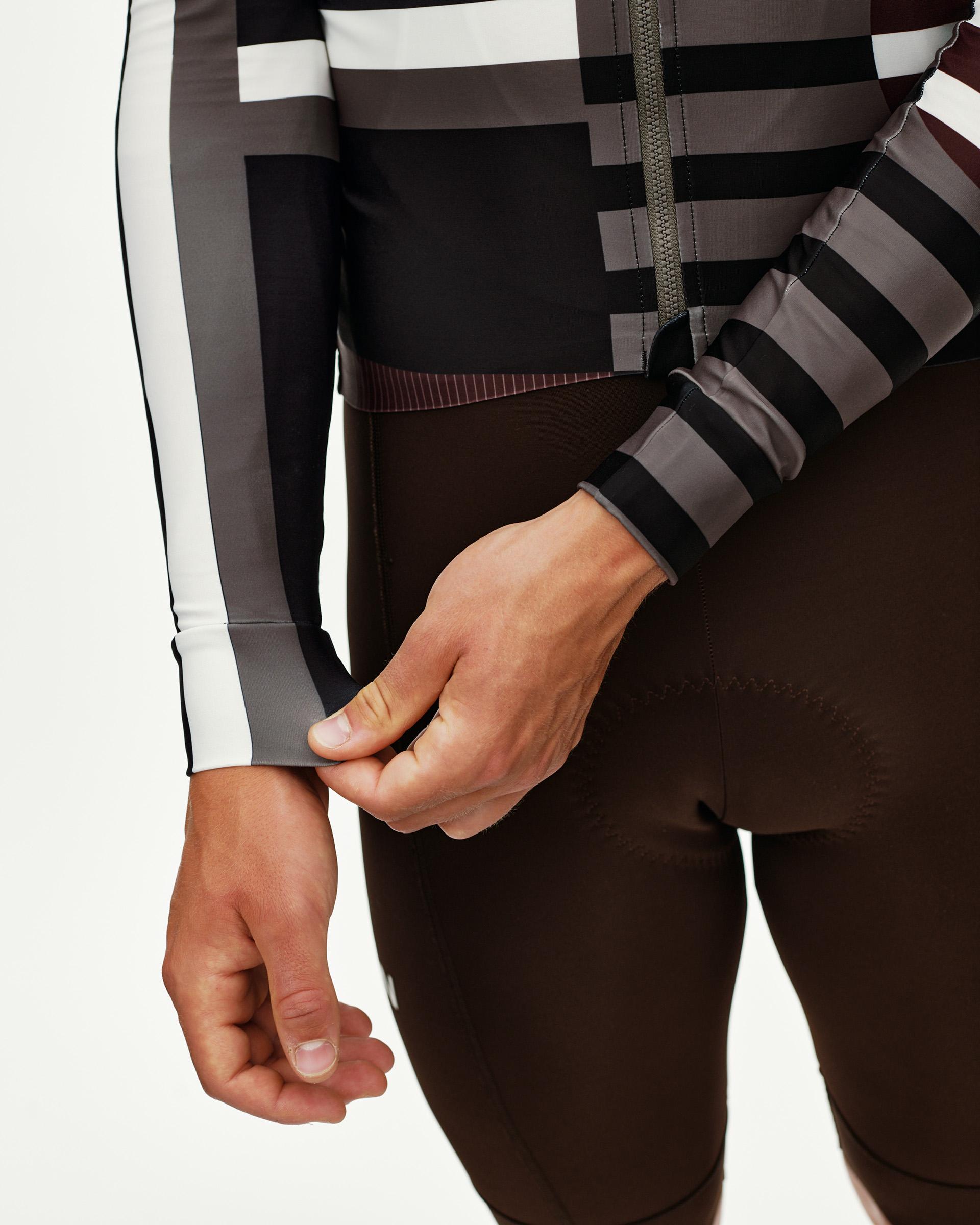 Dark Olive Mechanism long sleeve cycling jersey, side detail on model with geometric block print and striped cuff