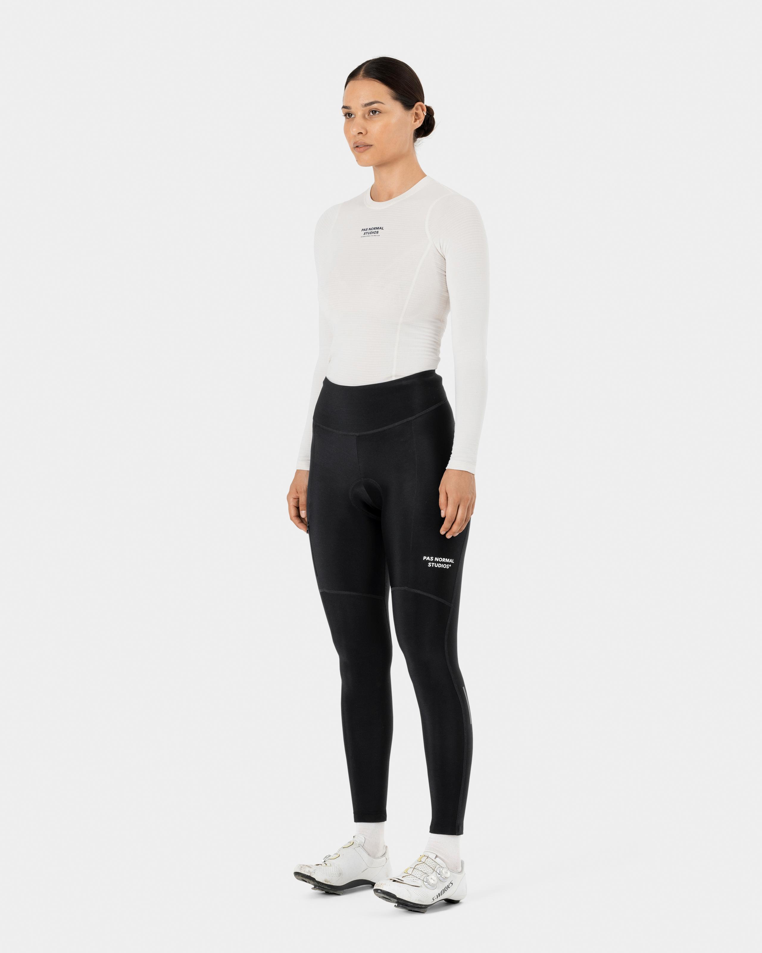Black Essential thermal long tights on model, three-quarter front view with white leg print
