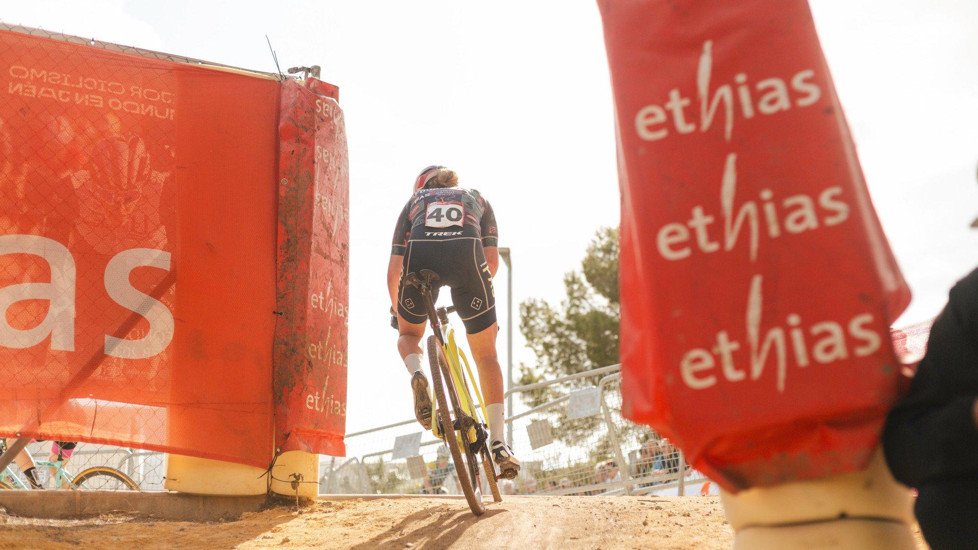 Cyclist racing through course markers wearing race number 40 jersey and shorts