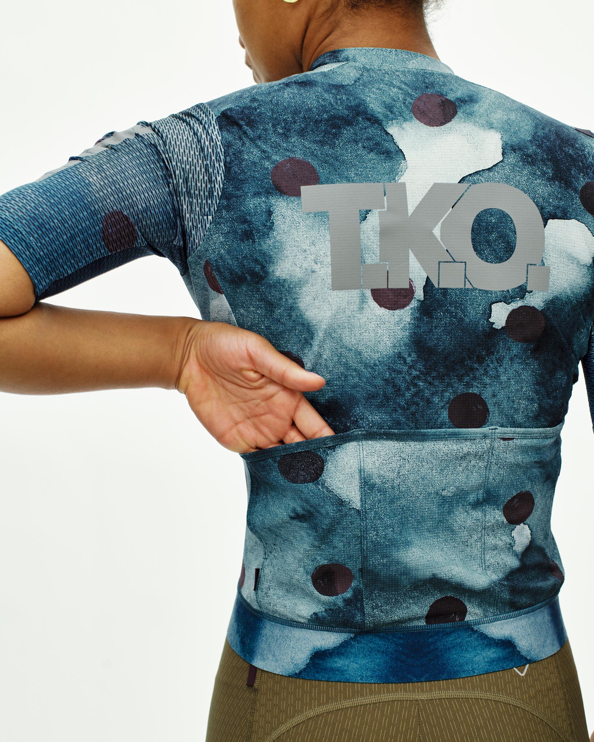 Dark Purple T.K.O. Essential Light cycling jersey on model, rear view with polka dot print and back pocket