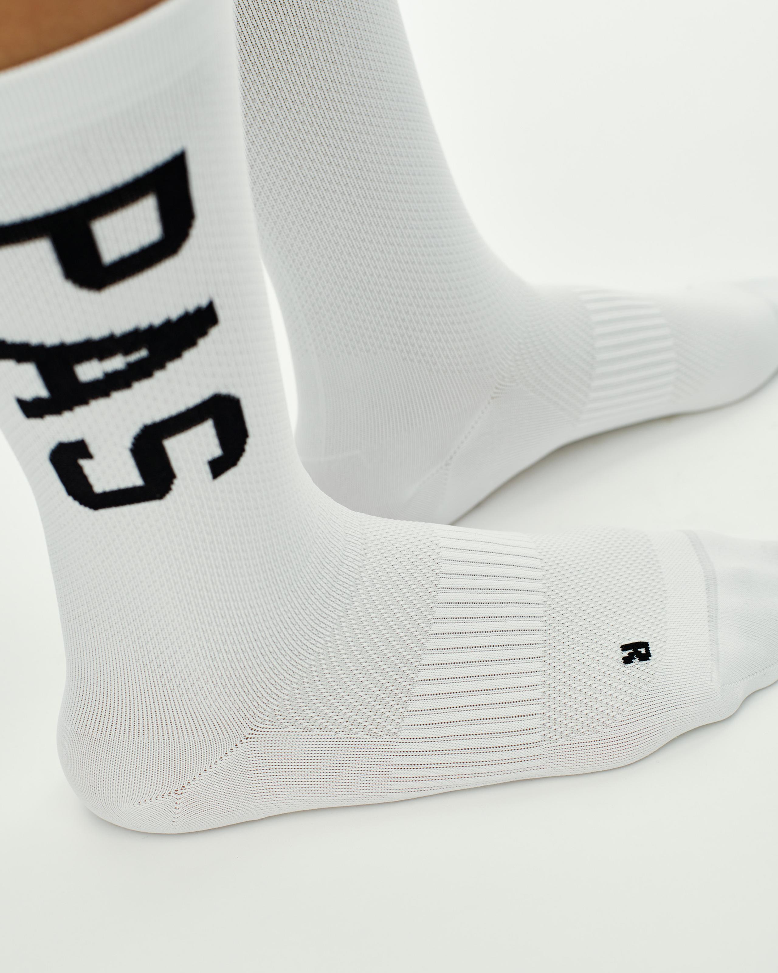 White PAS cycling socks with black logo lettering and textured sole panel