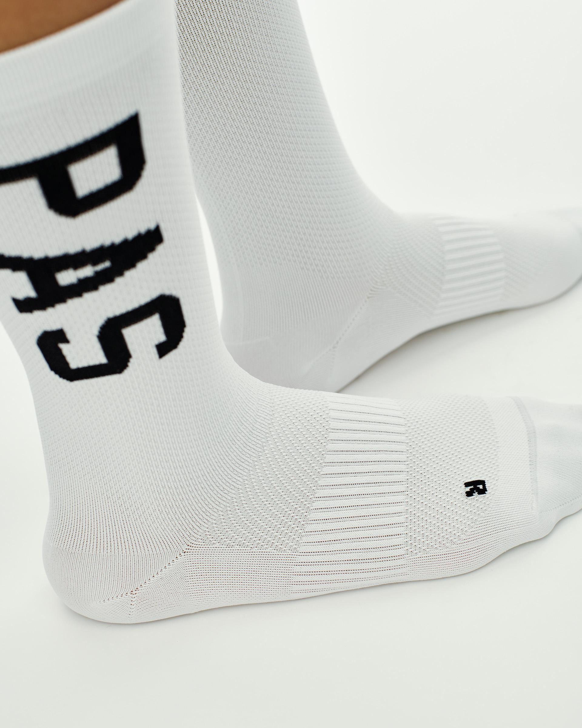 White PAS cycling socks with black logo lettering and textured sole panel