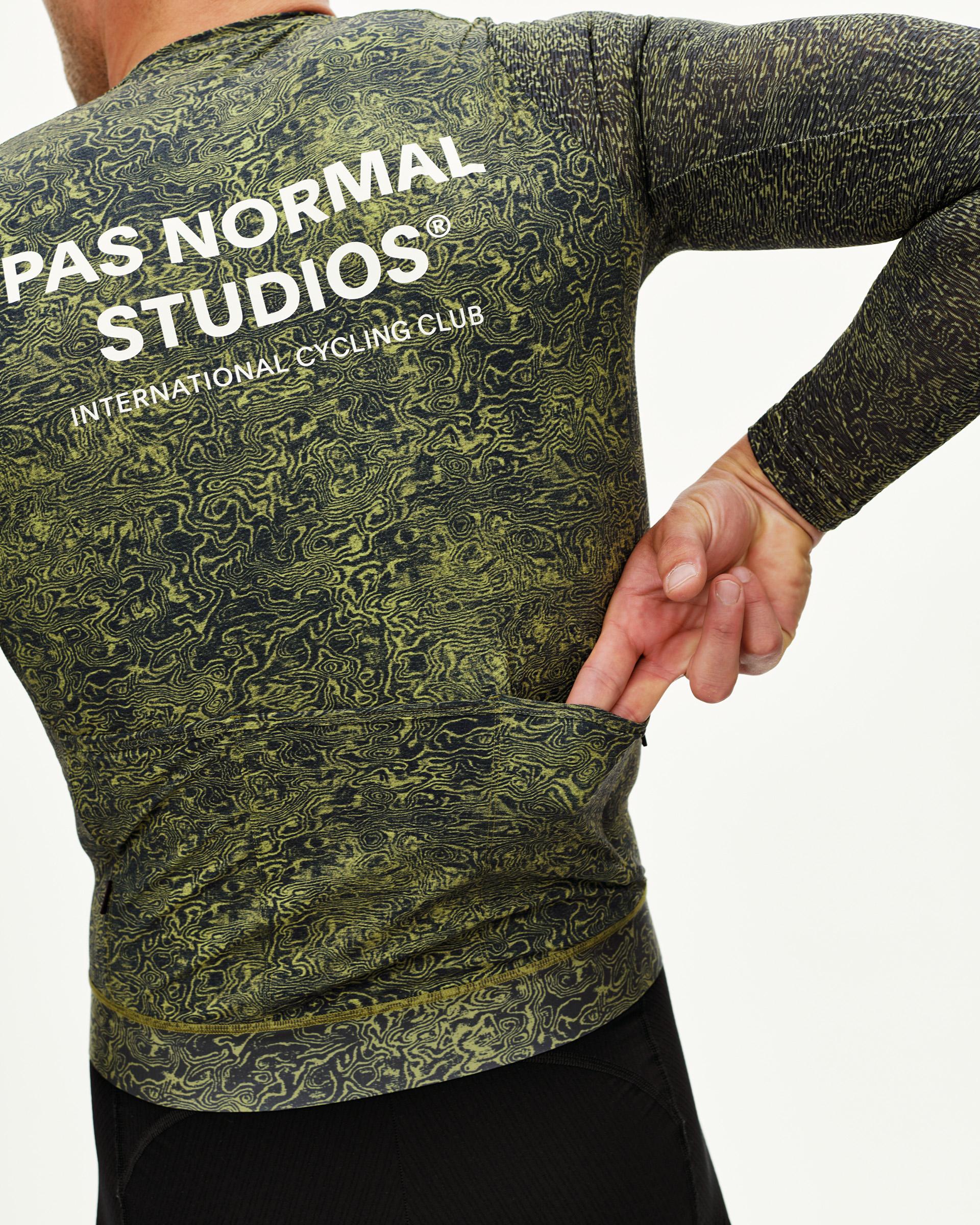 Dark Lime Essential long sleeve cycling jersey on model, rear view with topographic AOP and white back print