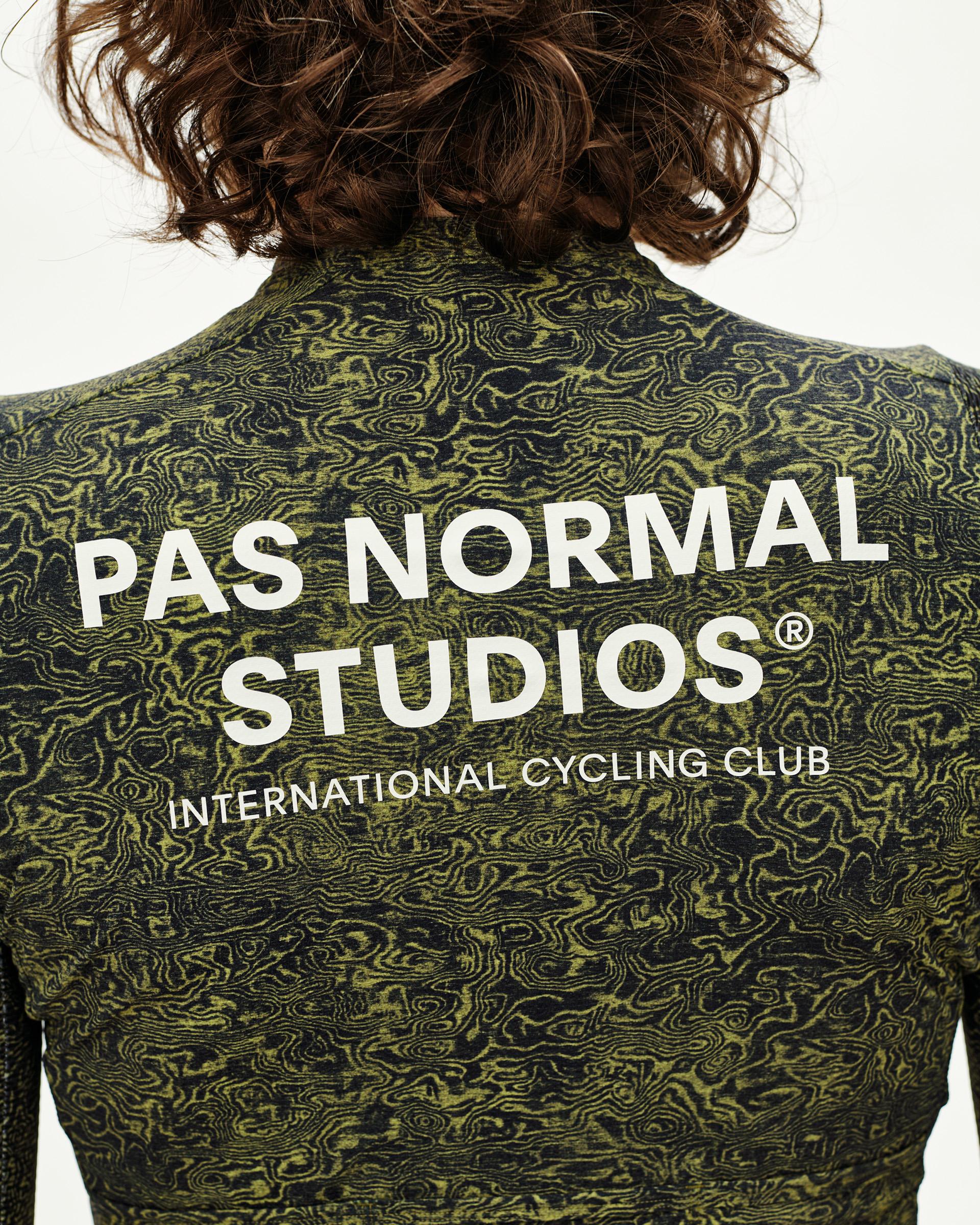 Dark Lime Essential cycling jersey, rear view on model with all-over topographic print and white back logo