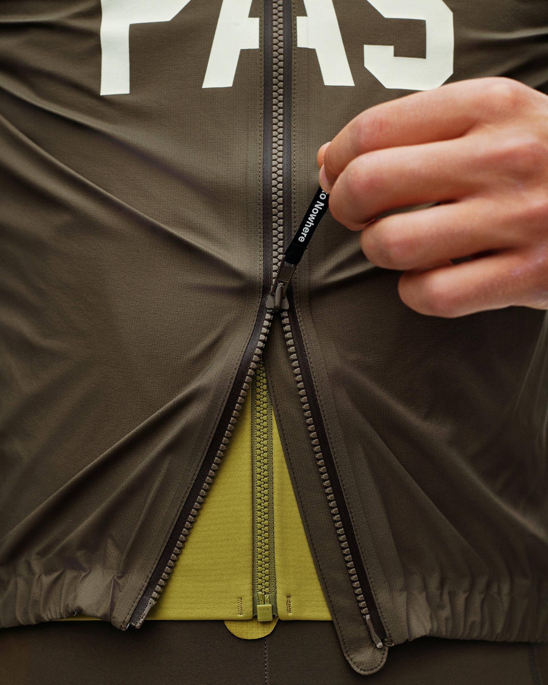 Dark Earth Mechanism Rain cycling jacket, front detail on model with full-length zip being opened and yellow inner layer