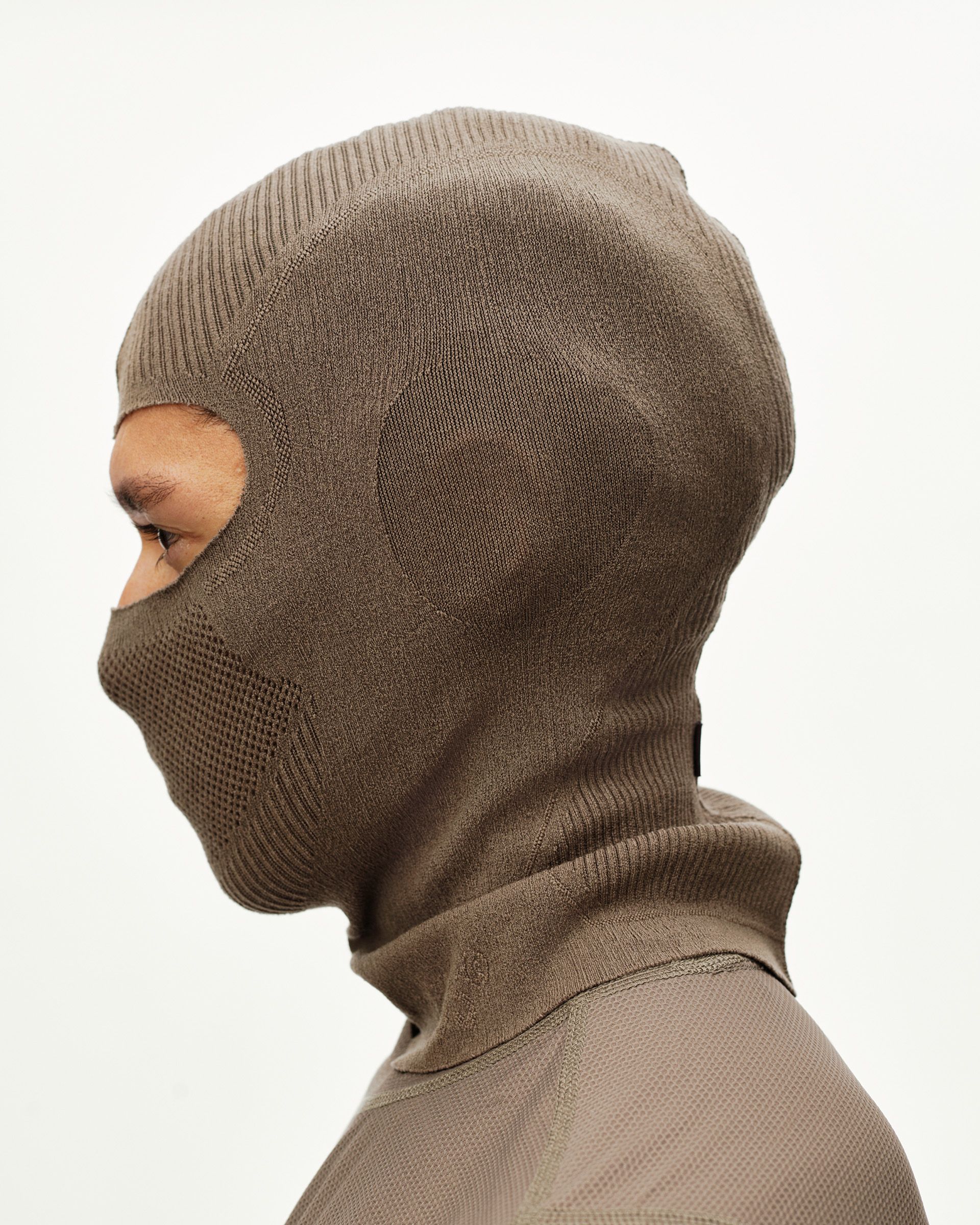 Stone Brown Balance cycling balaclava on model, side view with ribbed face opening and knit panel detail