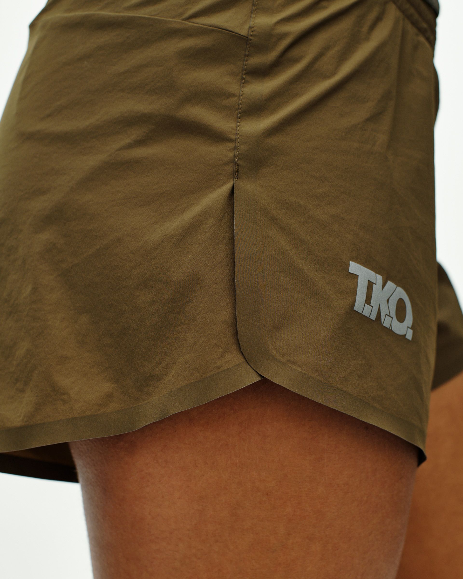 Brown T.K.O. Balance shorts on model with white logo on left hem